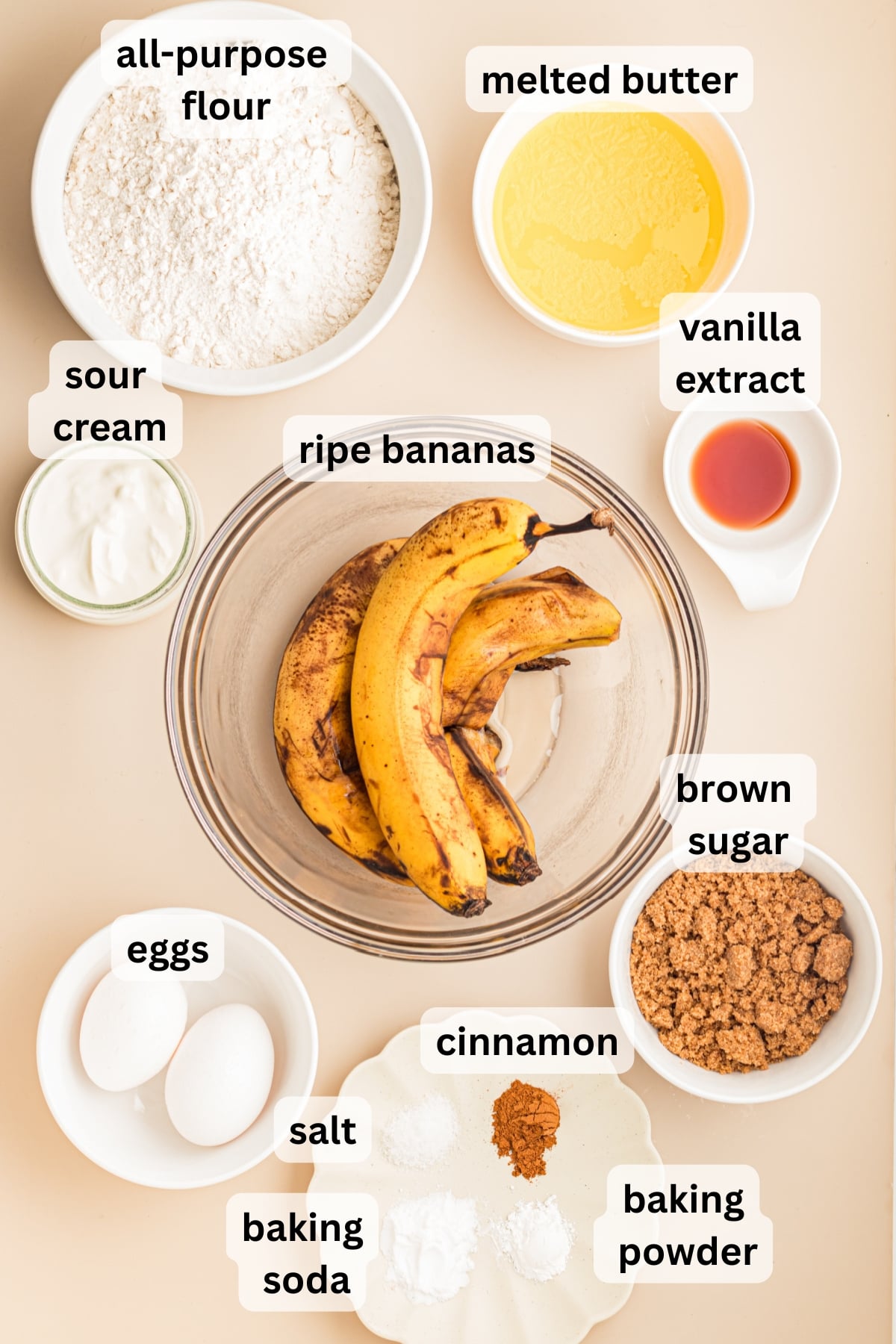 All of the ingredients needed to make banana bread with streusel topping in bowls on a table.