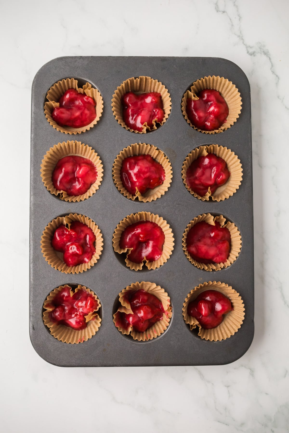 Cherry pie filling put into the liners in the muffin tin.
