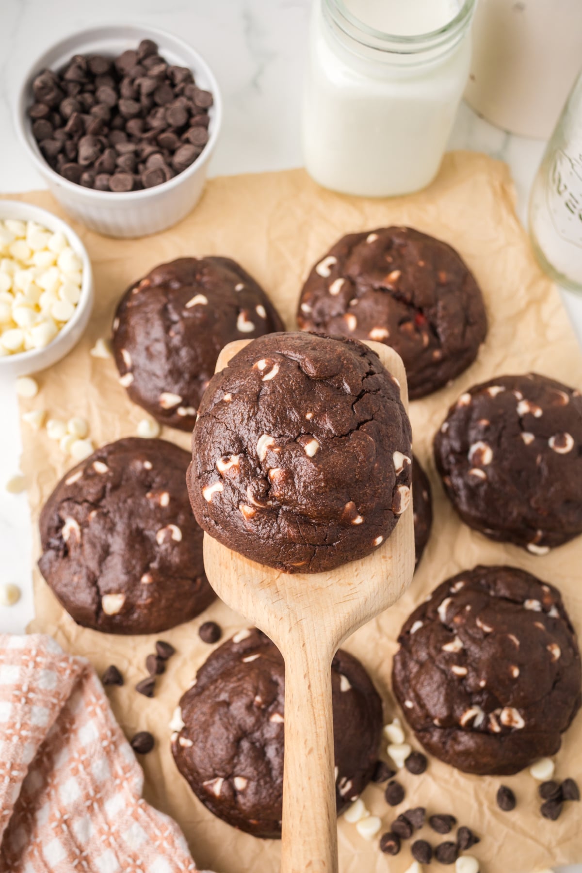 A chocolate cookie with cherries being held up in the air.