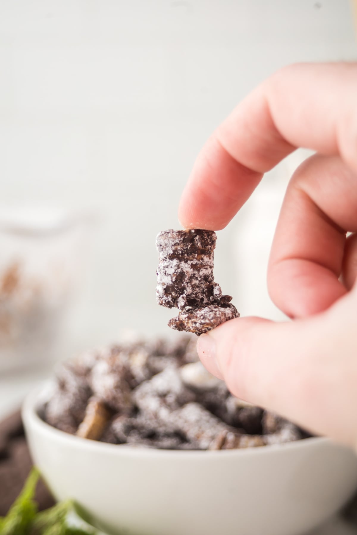 A few pieces of muddy buddies that are stuck together held in the air.
