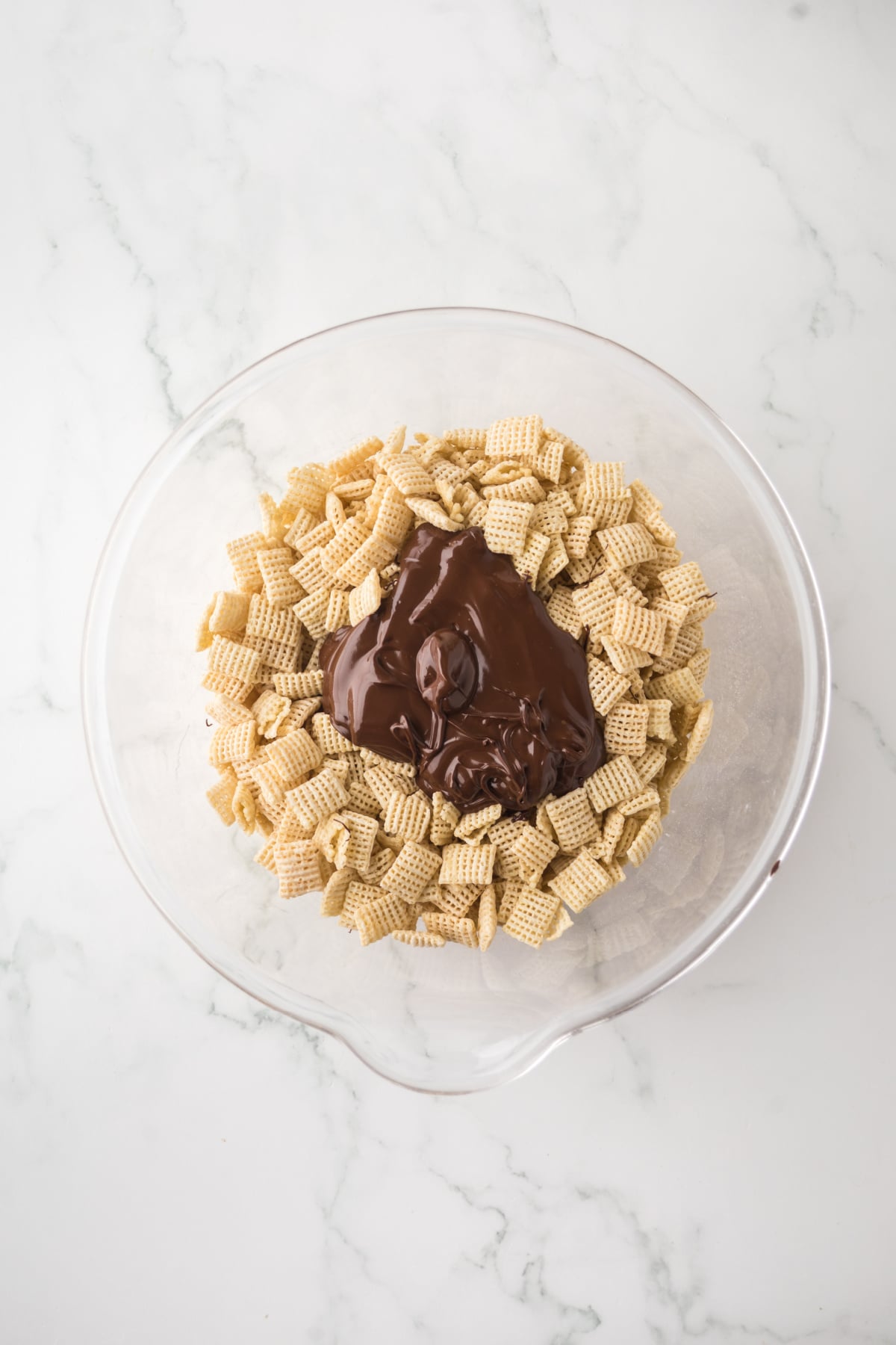 A bowl of Chex cereal covered in melted chocolate with mint extract.