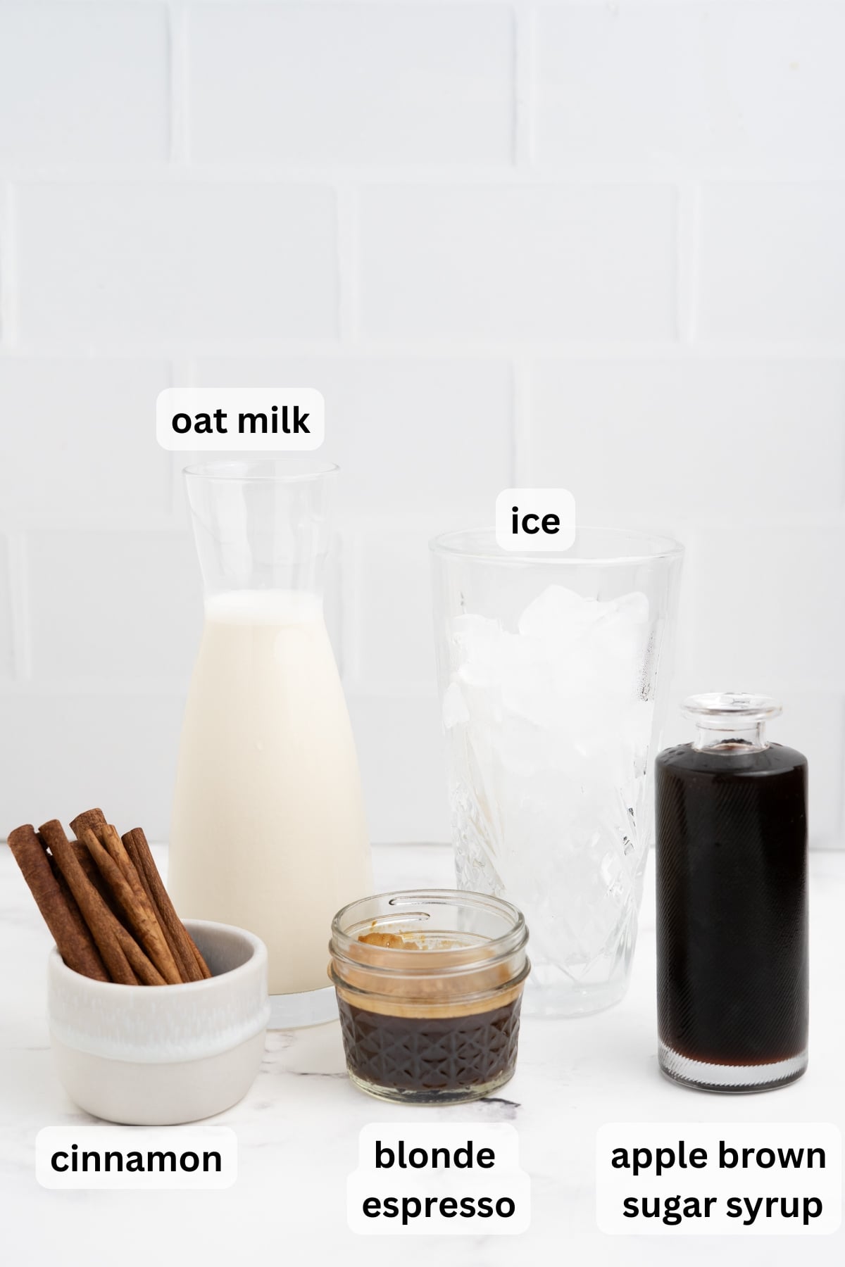 All of the ingredients needed to make Starbucks Apple Crisp Brown Sugar Shaken Espresso in glasses on table.
