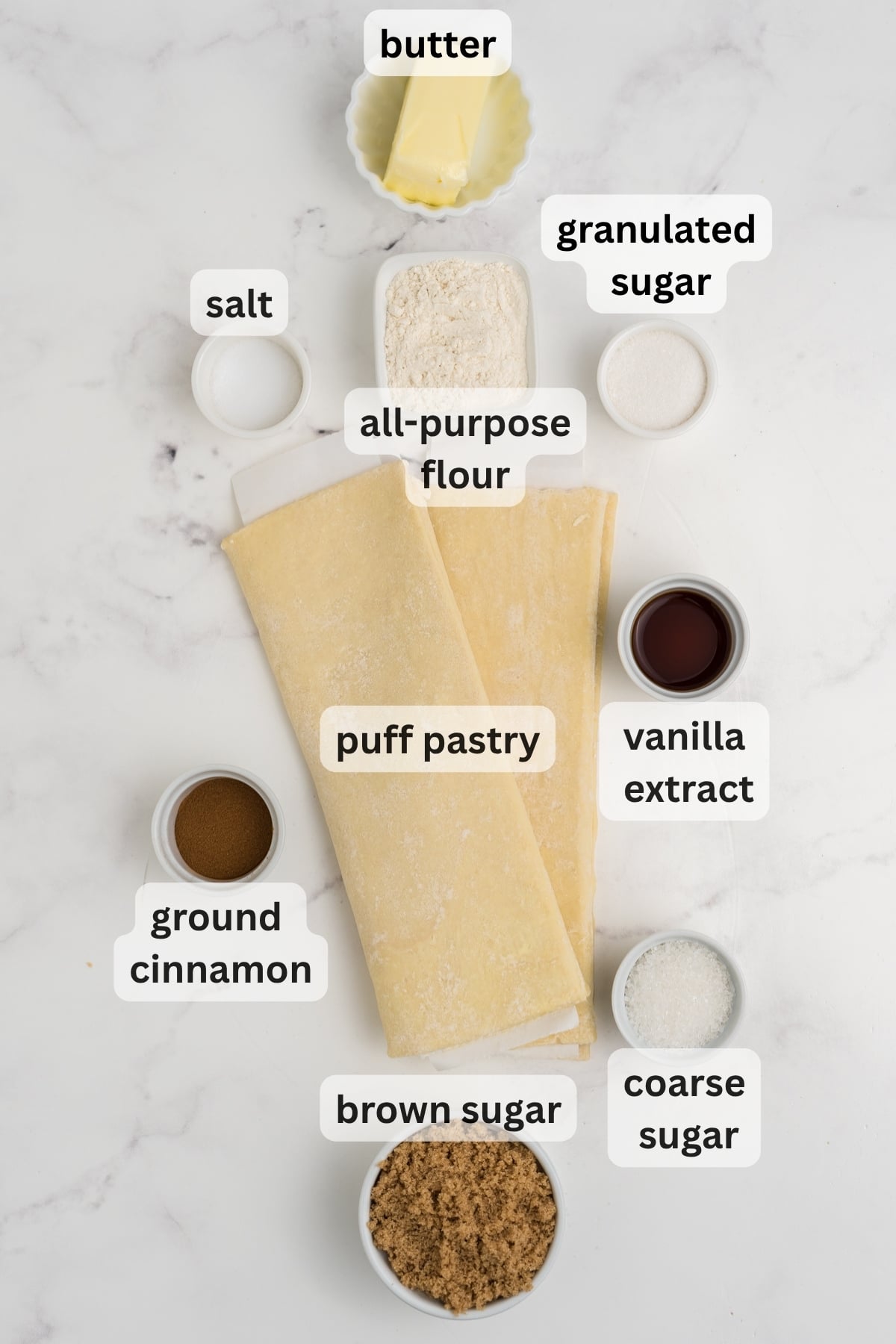 Ingredients for homemade cinnamon pull-aparts arranged in bowls on a counter.