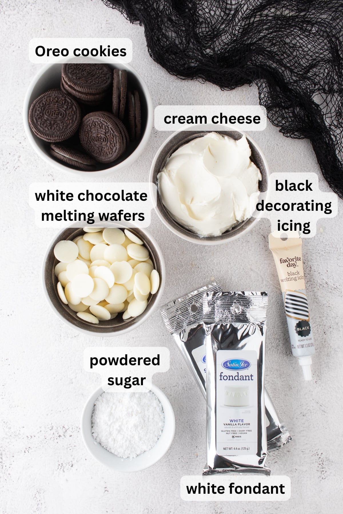 All of the ingredients needed to make Ghost Oreo Truffles in bowls on a table.