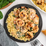 Plated Marry Me Chicken Meatballs on a bed of orzo.