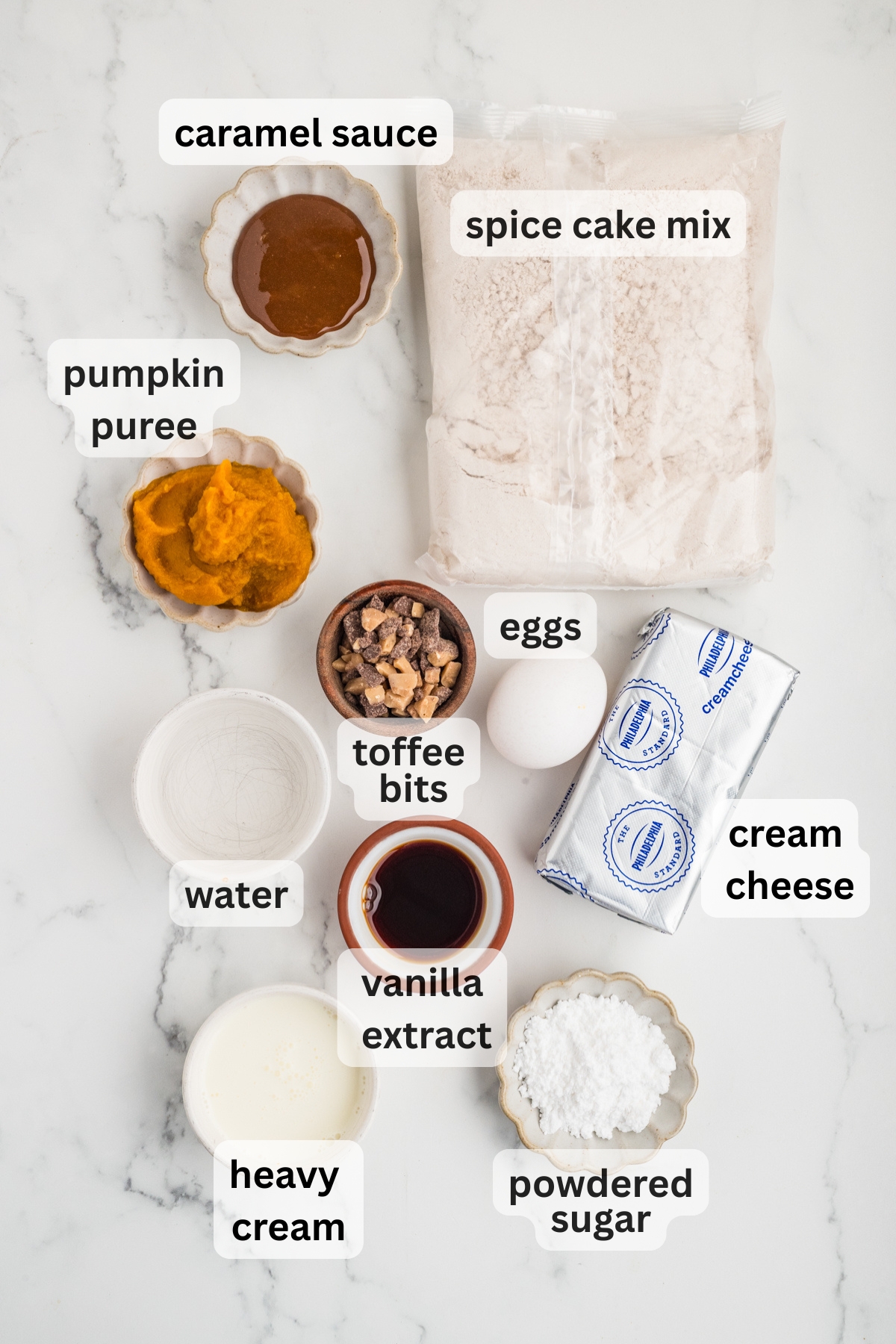 All of the ingredients needed to make a Pumpkin Poke Cake in bowls on a table.