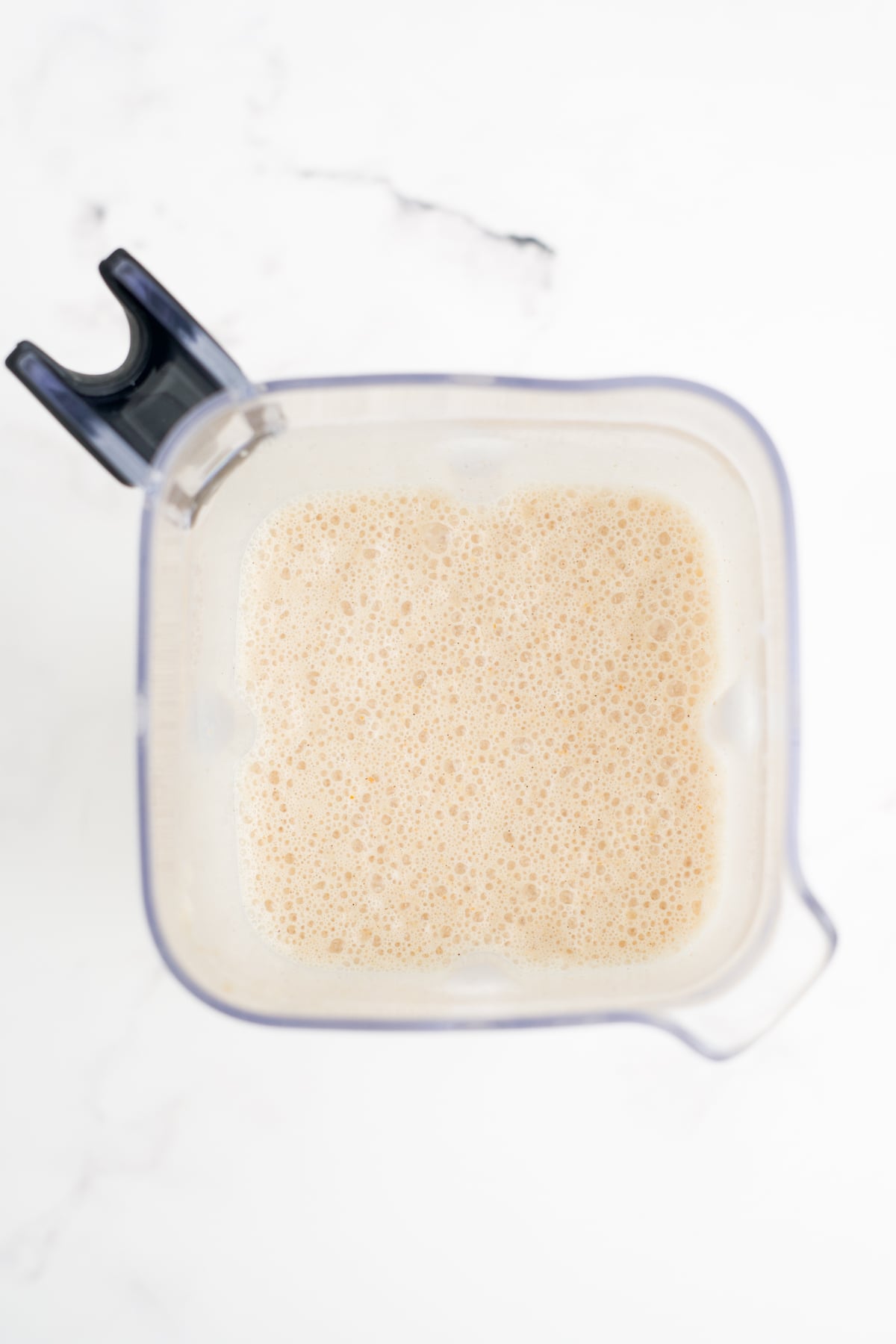 All of the ingredients needed to make a Frappuccino blended in a blender.