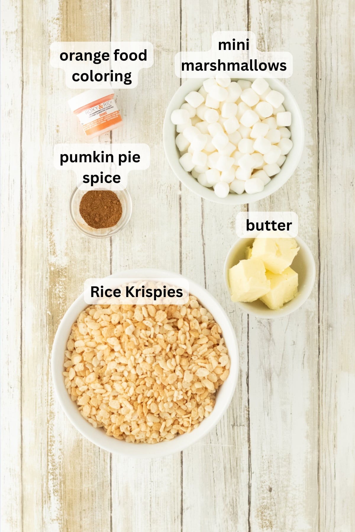 All of the ingredients needed to make a Rice Krispie Treat pumpkin pie in bowls on a table.