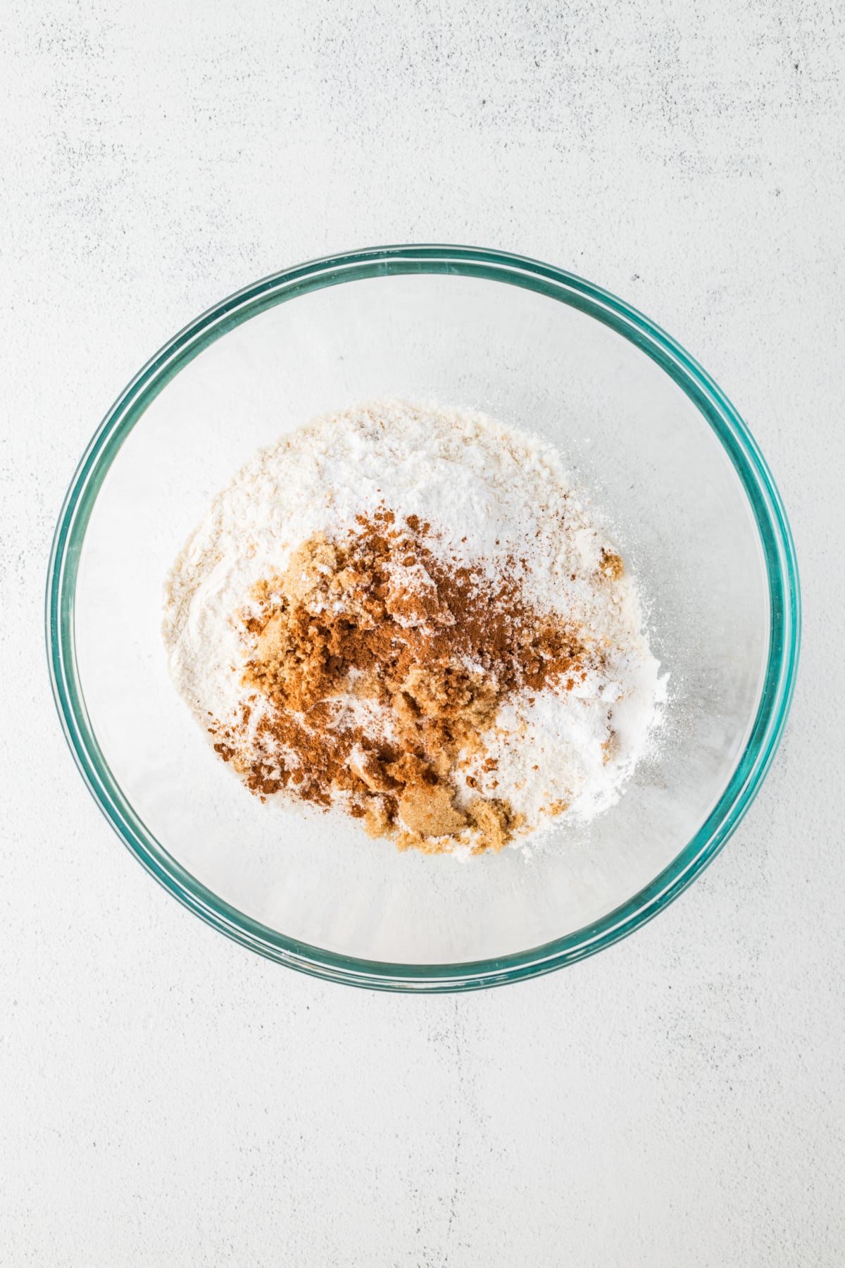 Flour, brown sugar, pumpkin pie spice, baking powder, and salt added to bowl.