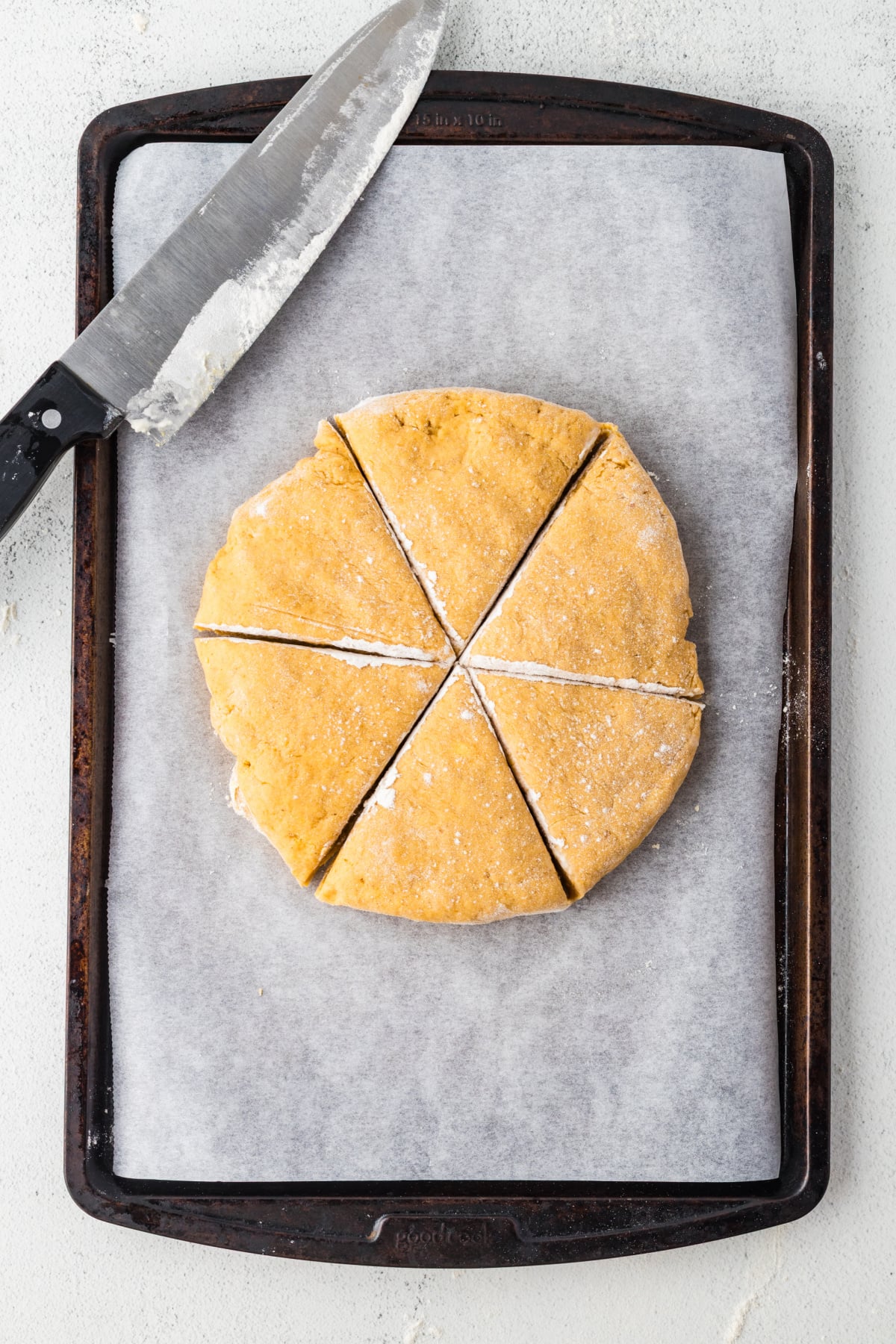Dough cut into six scones on baking sheet.