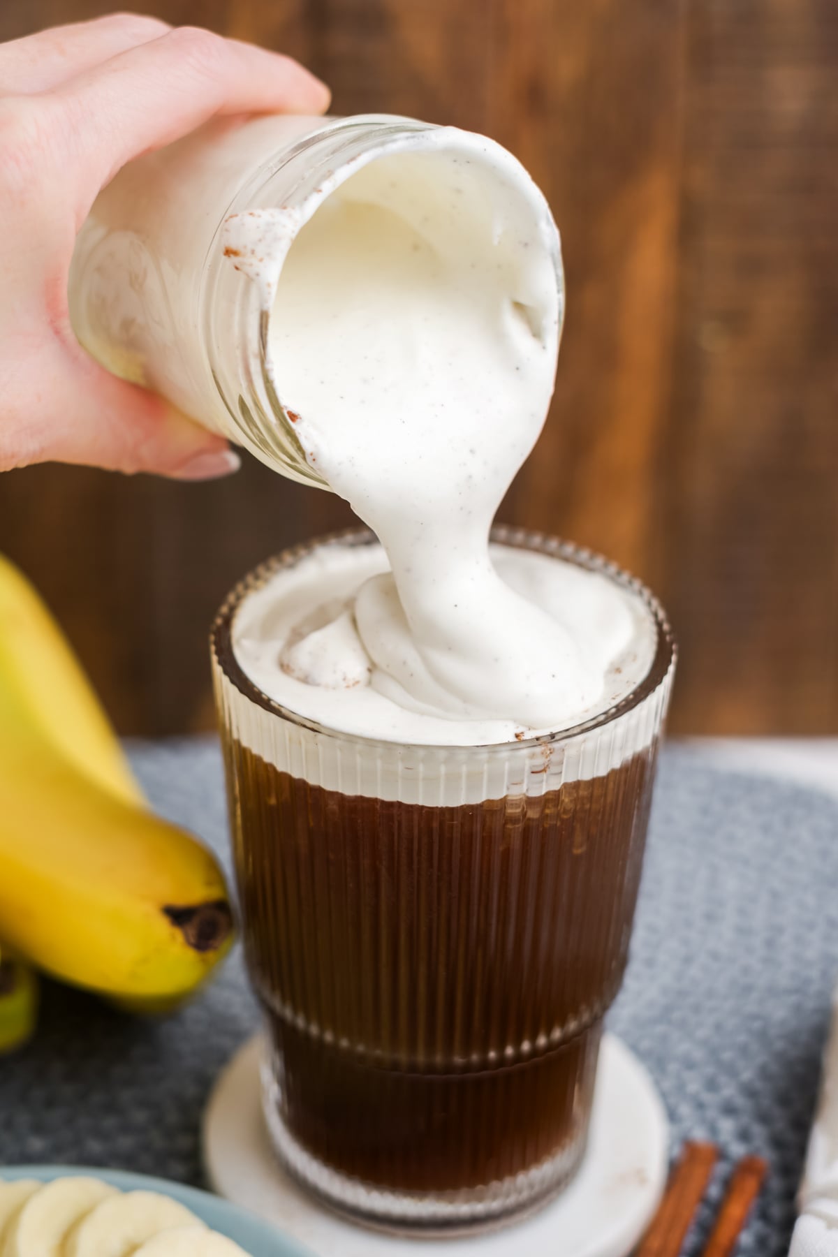 Cold Foam being poured on the top of a cold coffee.