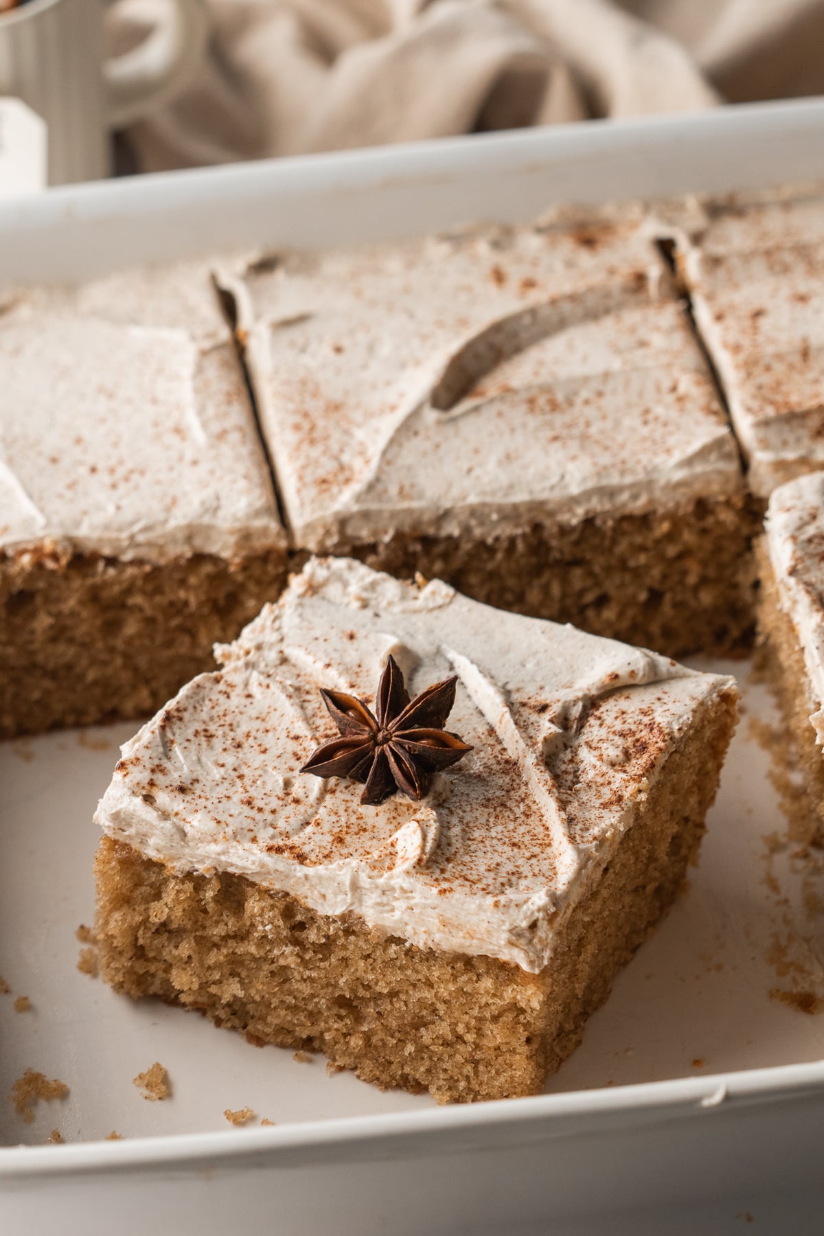 Frosted cake sliced into squares in 9x13-inch pan missing a few slices.