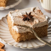 Slice of chai cake with chai buttercream on a plate with a fork pressing in.