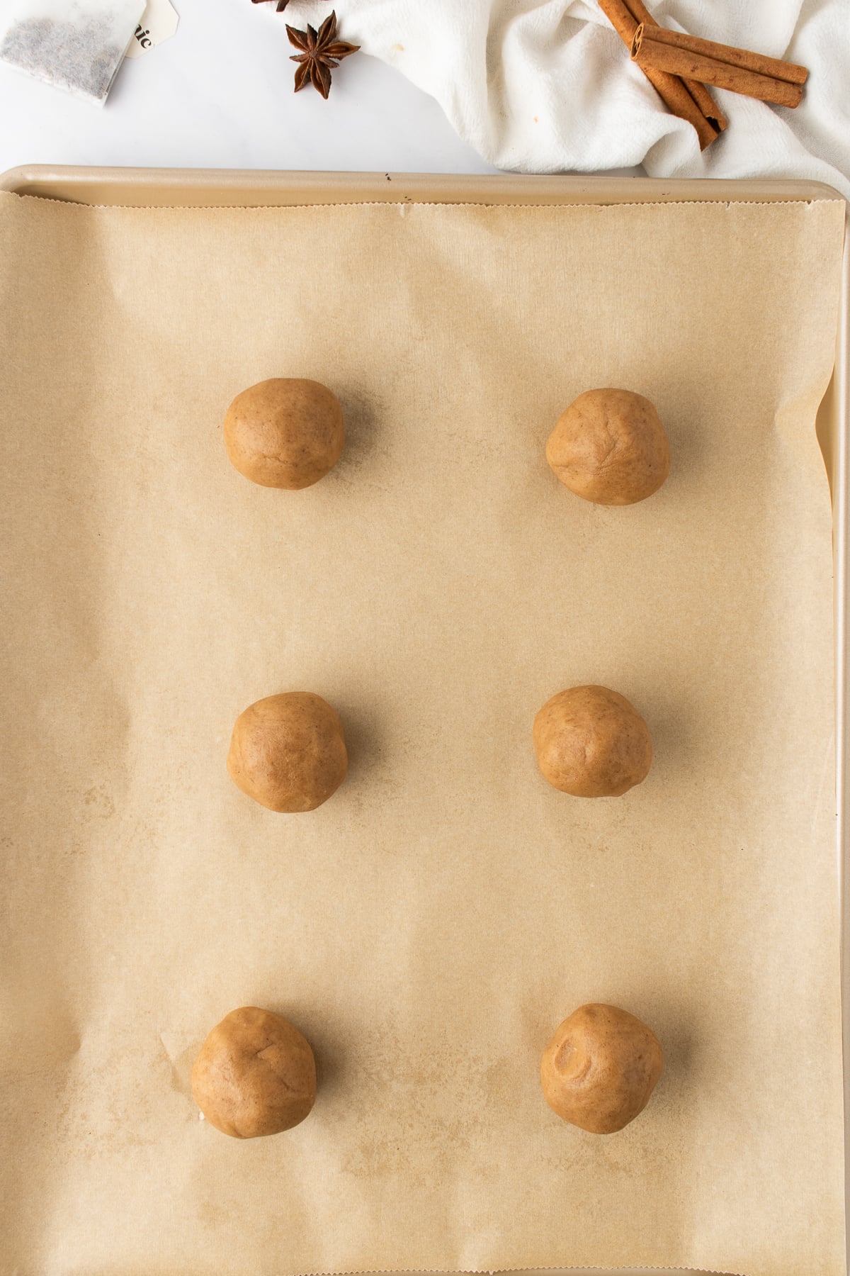 Cookie dough rolled into balls on a parchment lined cookie sheet.