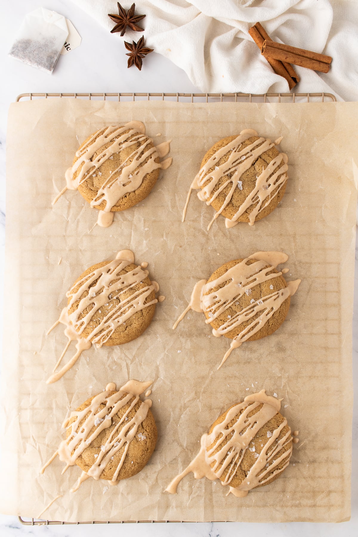 Glaze drizzled on cookies on a parchment covered rack.