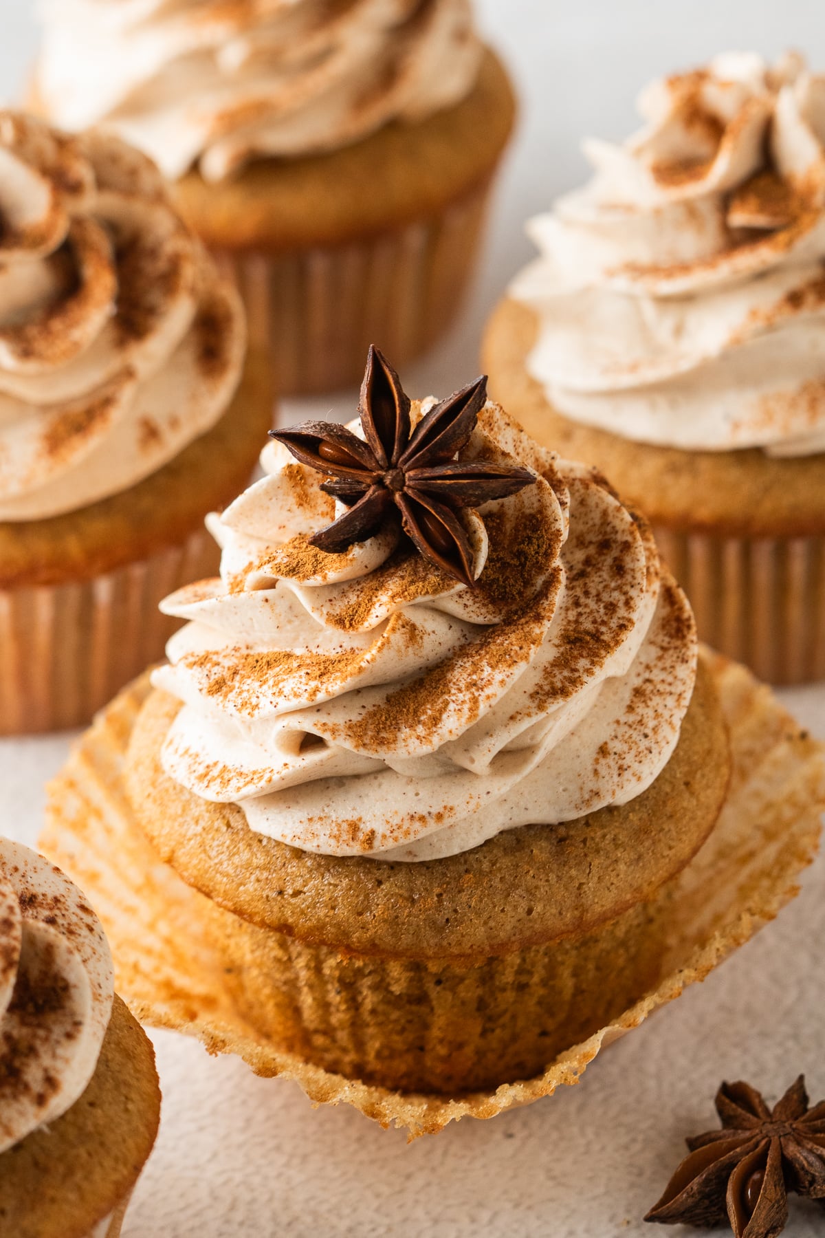 Cupcakes on a serving platter with one in front with liner opened.