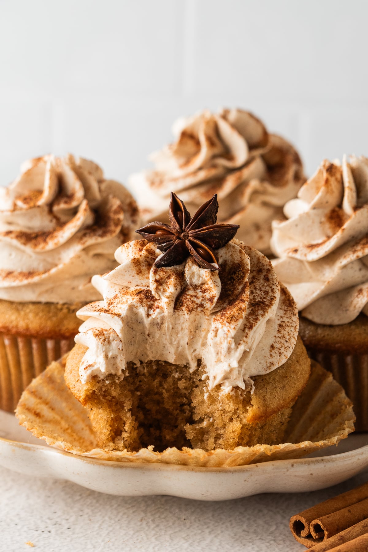 Cupcakes on platter with one in front with opened liner missing a bite.