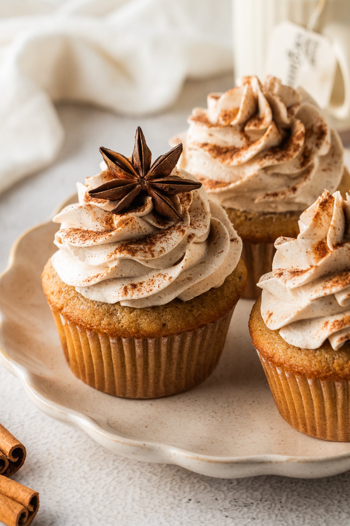 Cupcakes on a serving platter with one in center with a star anise on top of the buttercream.