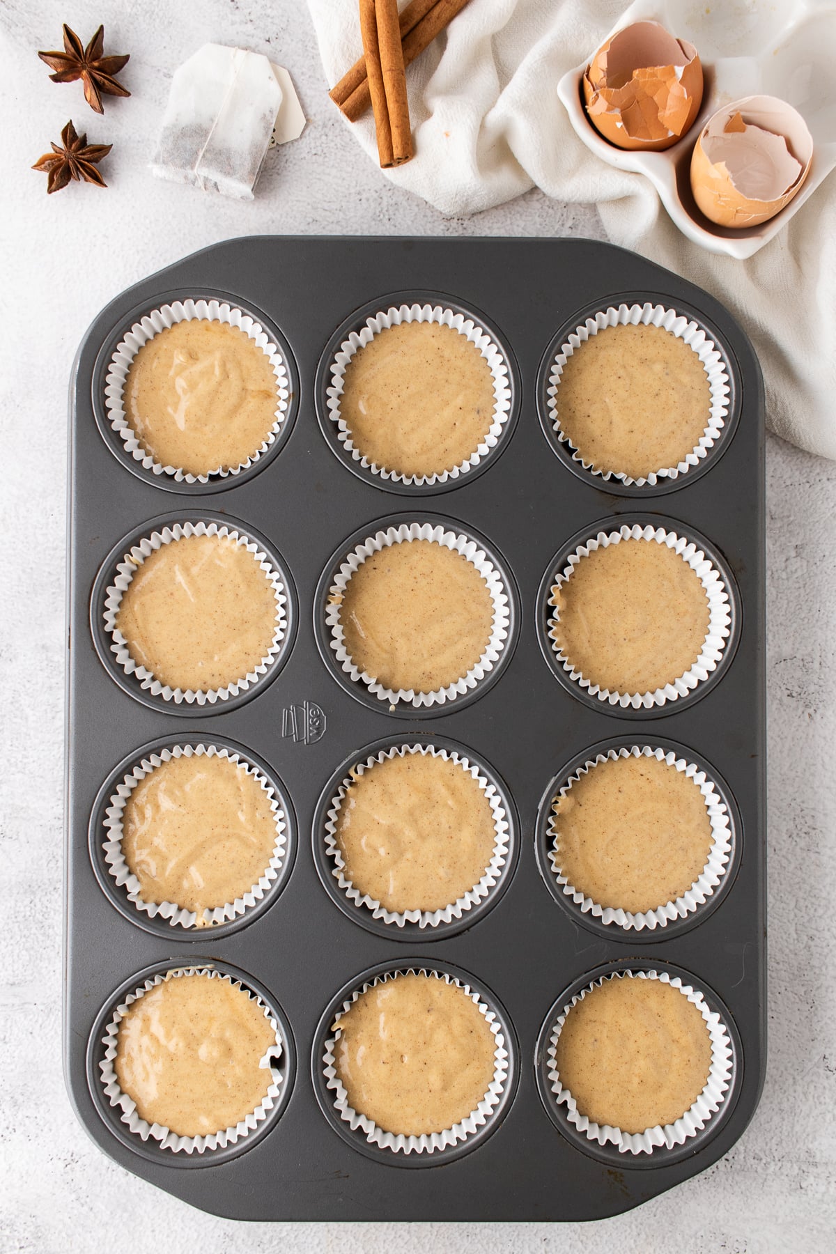 Cupcake batter divided among liners in a muffin pan.