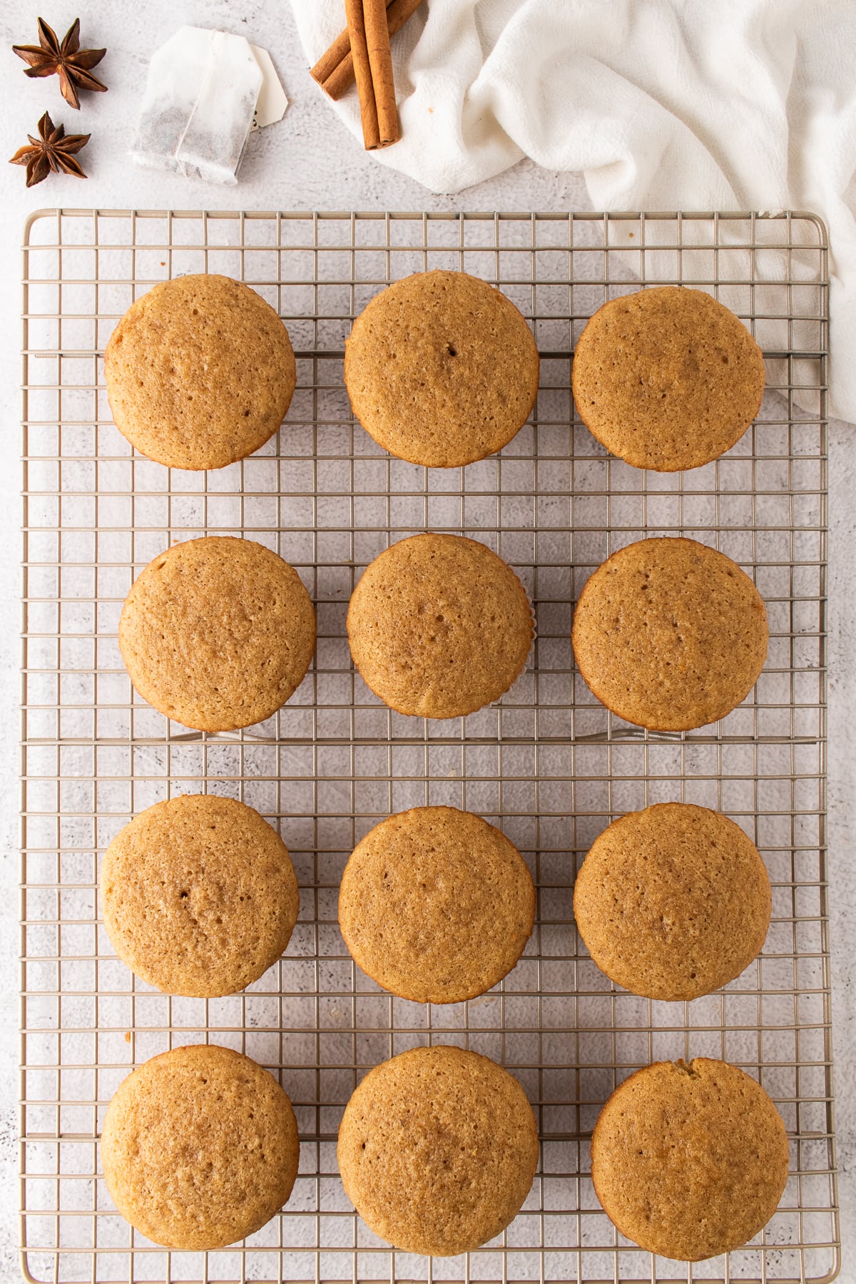 Freshly baked cupcakes cooling on a wire rack.