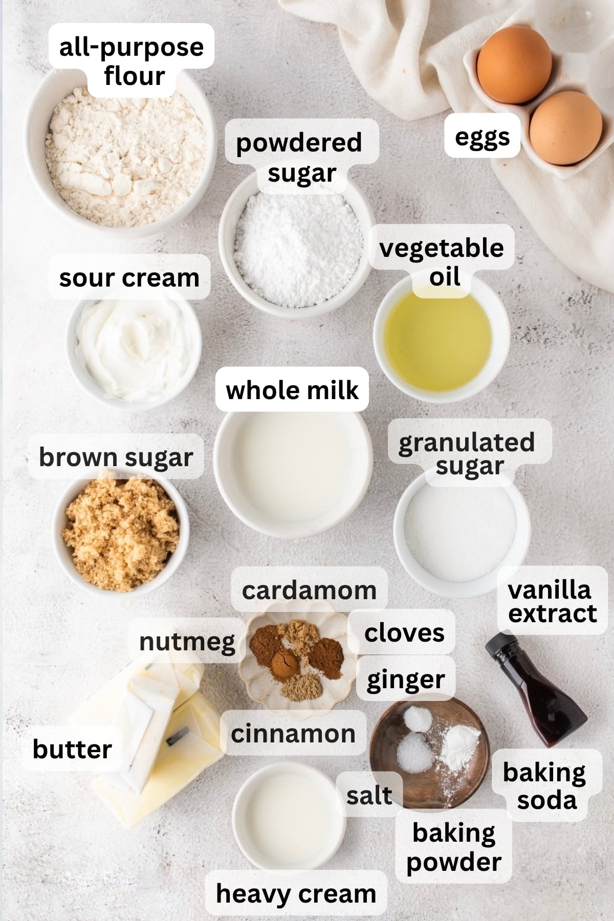 All of the ingredients needed to make chai cupcakes in bowls on a table.