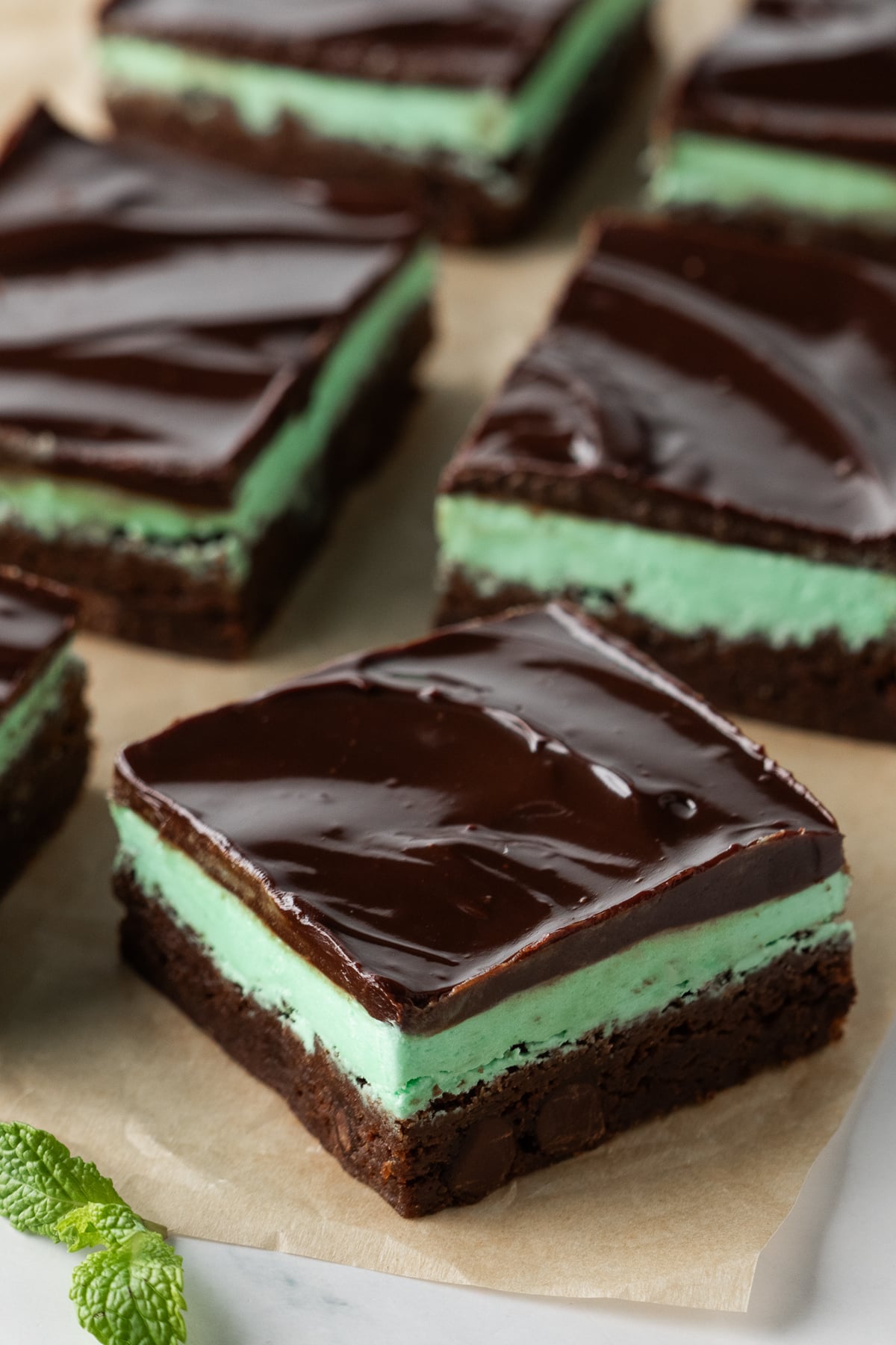 Sliced brownies on parchment covered table.