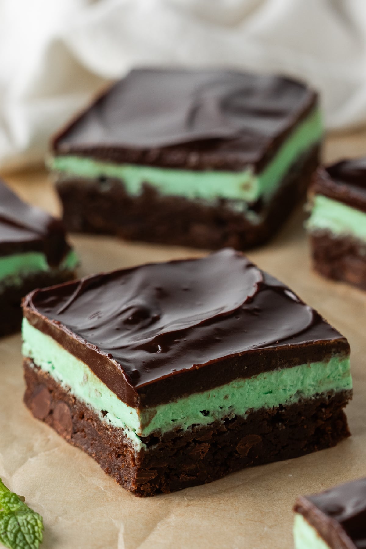 Sliced brownies on parchment covered table showing three layers.