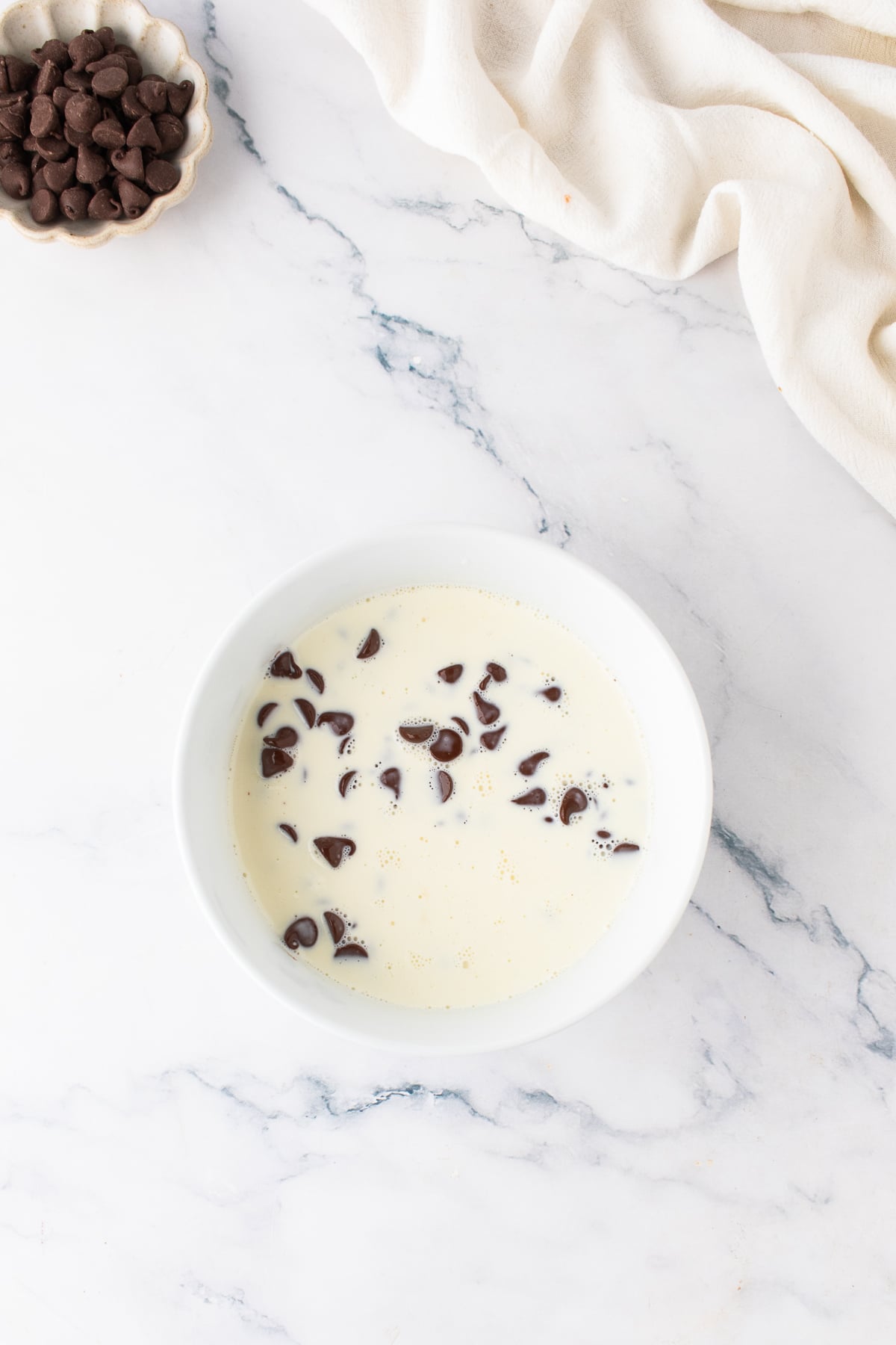 Heavy cream and chocolate chips in a bowl.