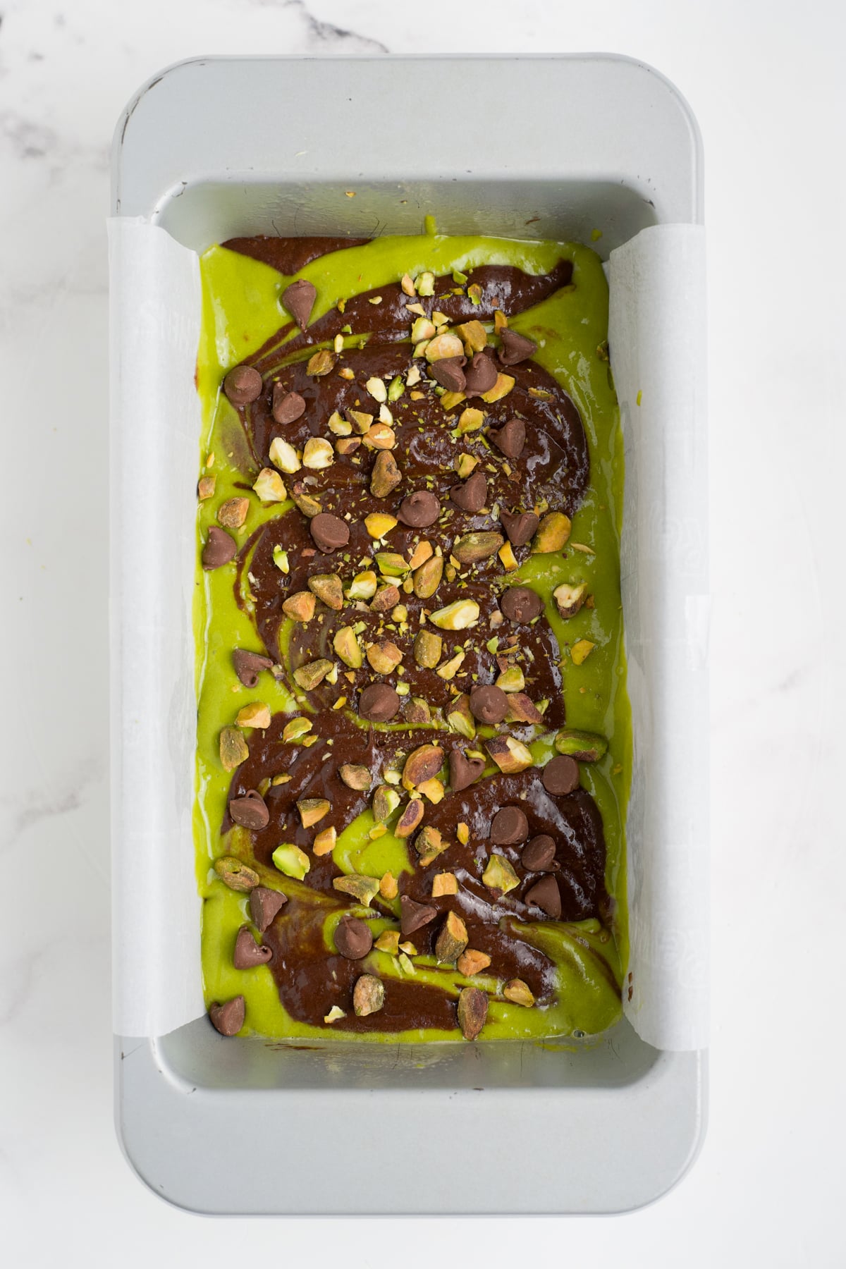 Batter swirled with knife in loaf pan topped with chopped pistachios and remaining chocolate chips.