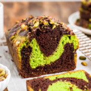Chocolate Pistachio Loaf on a platter showing swirled pistachio and chocolate cake with pistachios on top.