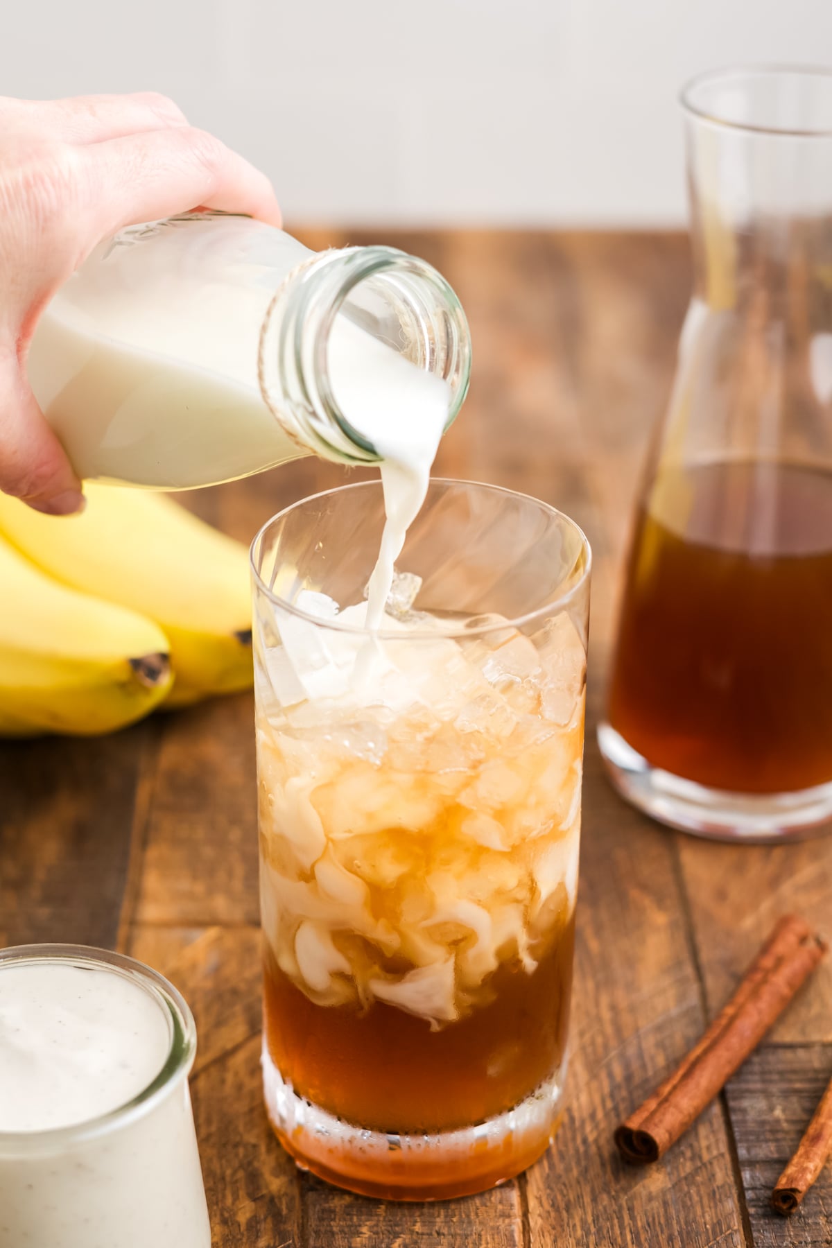 Oat milk poured into glass full of all of the other ingredients.