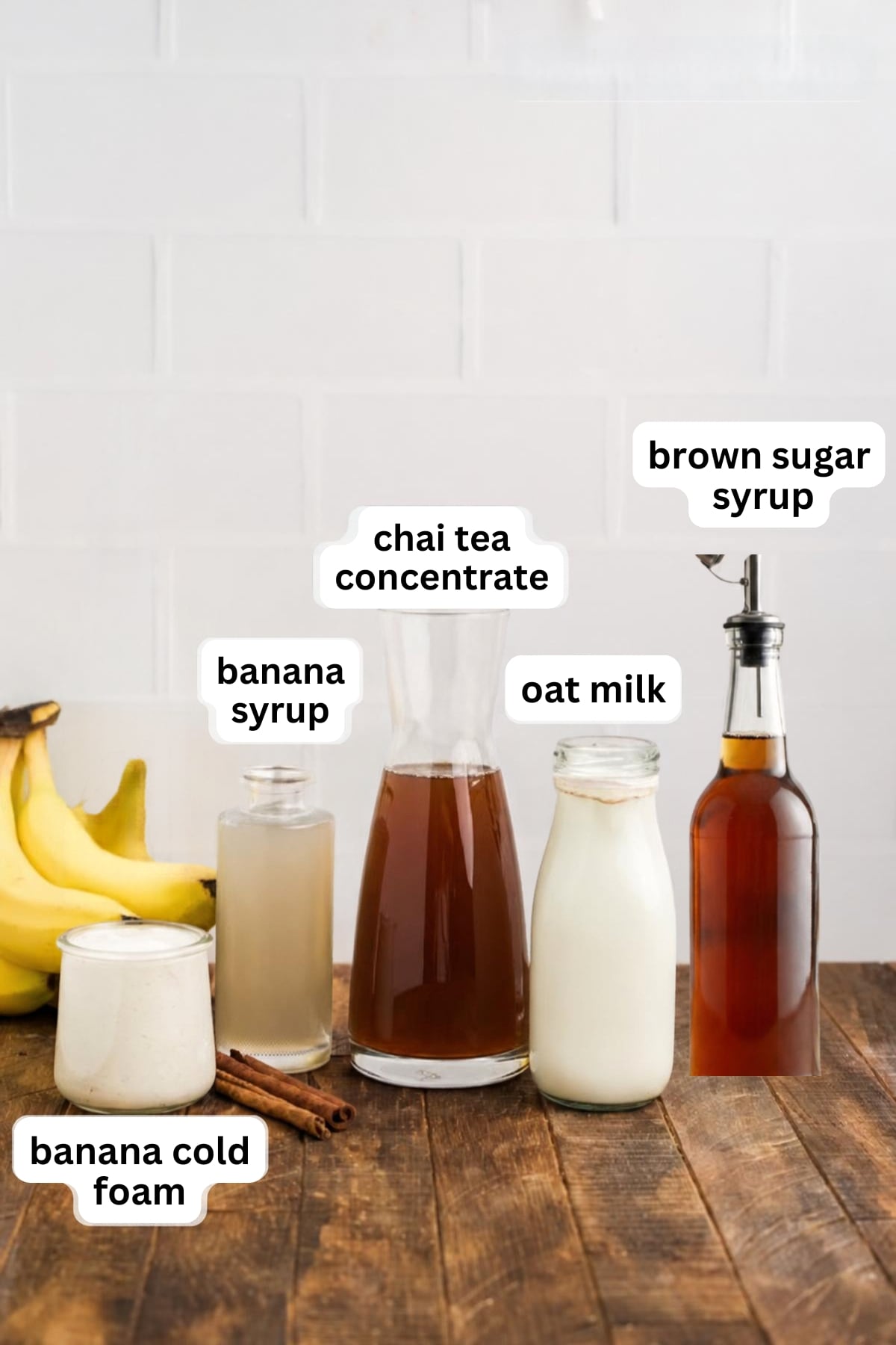 All of the ingredients needed to make an Iced Banana Bread Chai in glasses on a table.