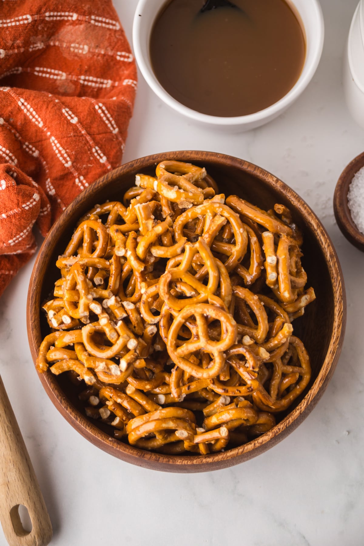 Pretzels coated with caramel and flaky sea salt in a serving bowl