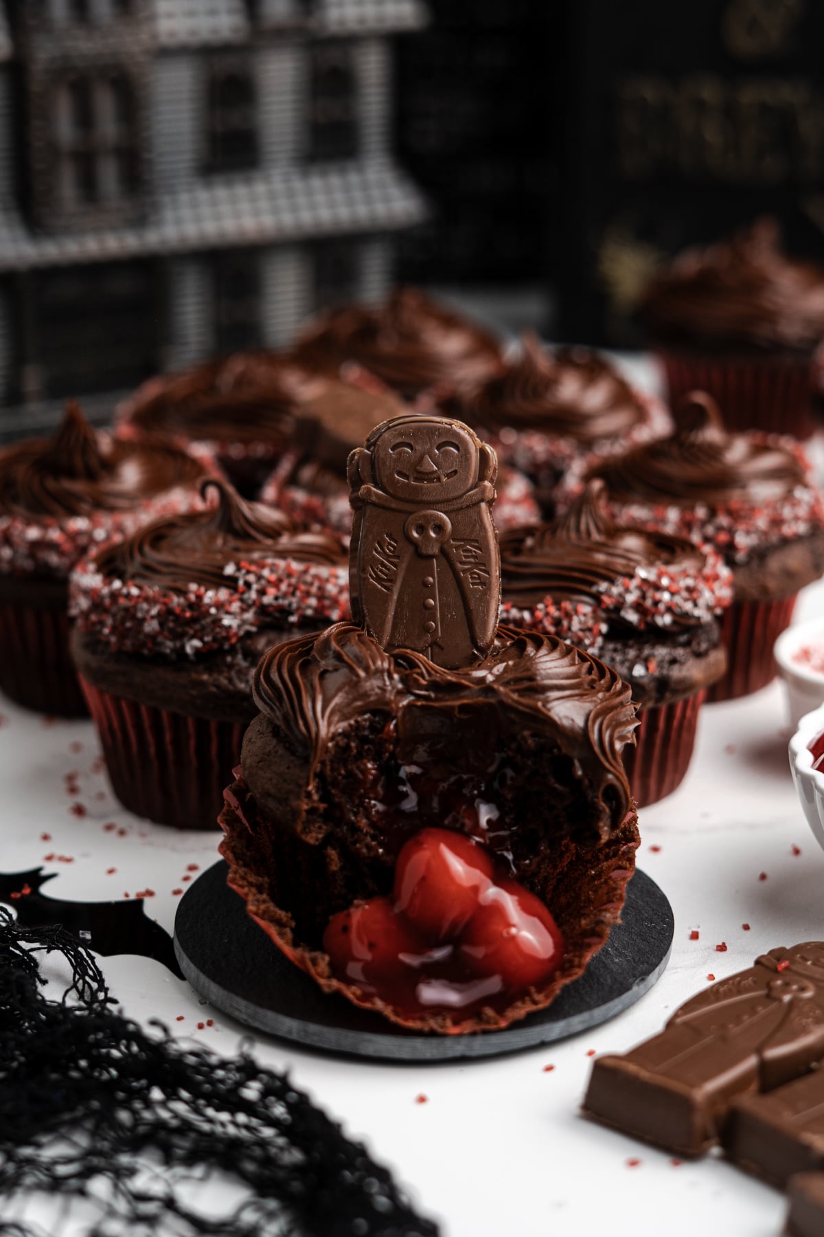 Cupcakes on a table with one in center broken open showing cherries.