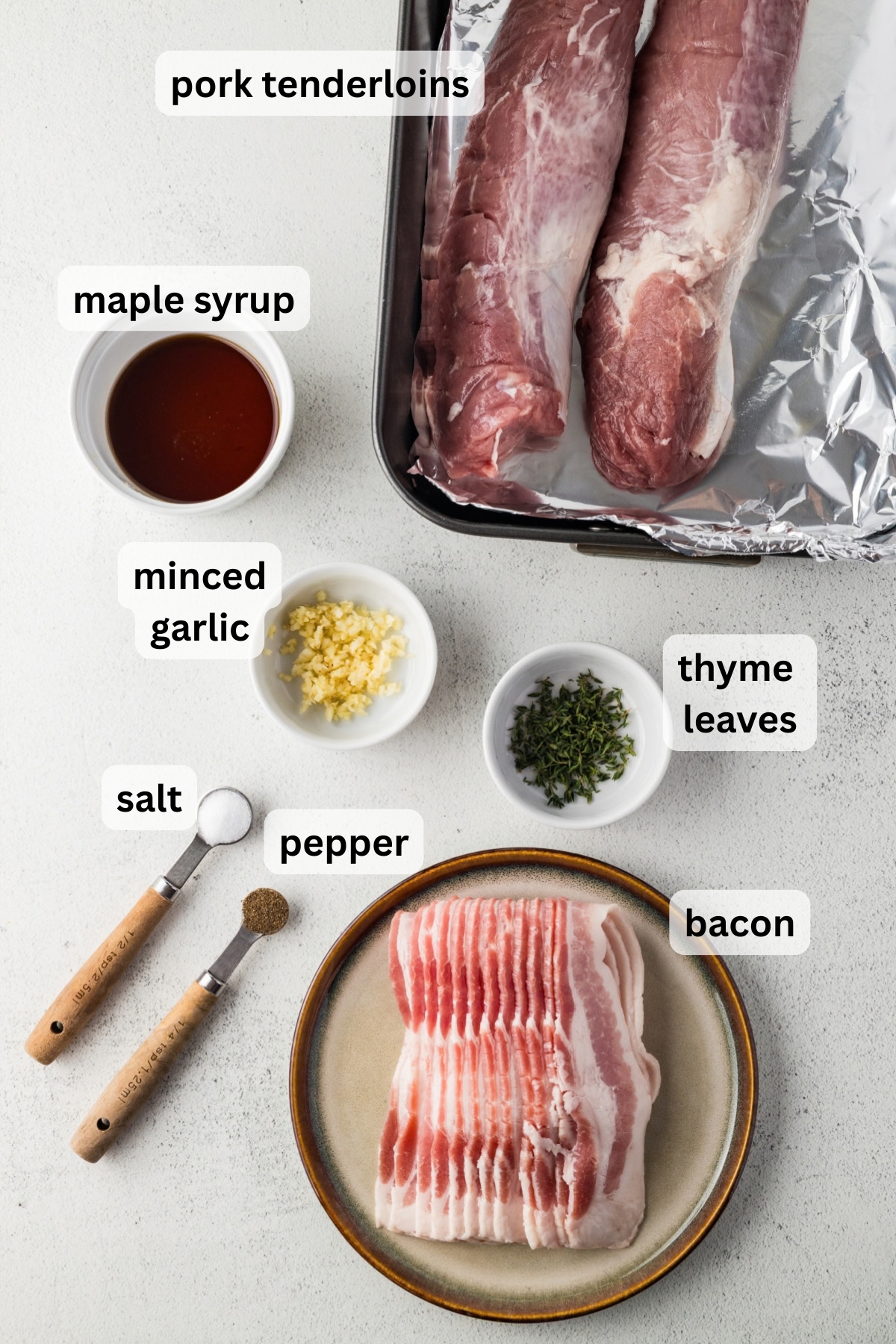 All of the ingredients needed to make bacon wrapped pork tenderloin in bowls on a table.