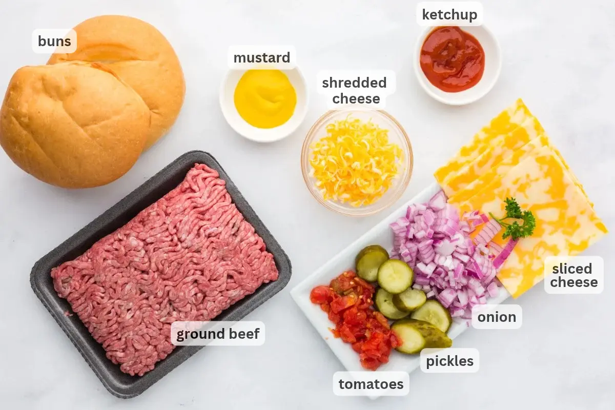 Ingredients for cheeseburger rolls including beef, cheese, burger buns, tomatoes, and condiments in bowls on a table.