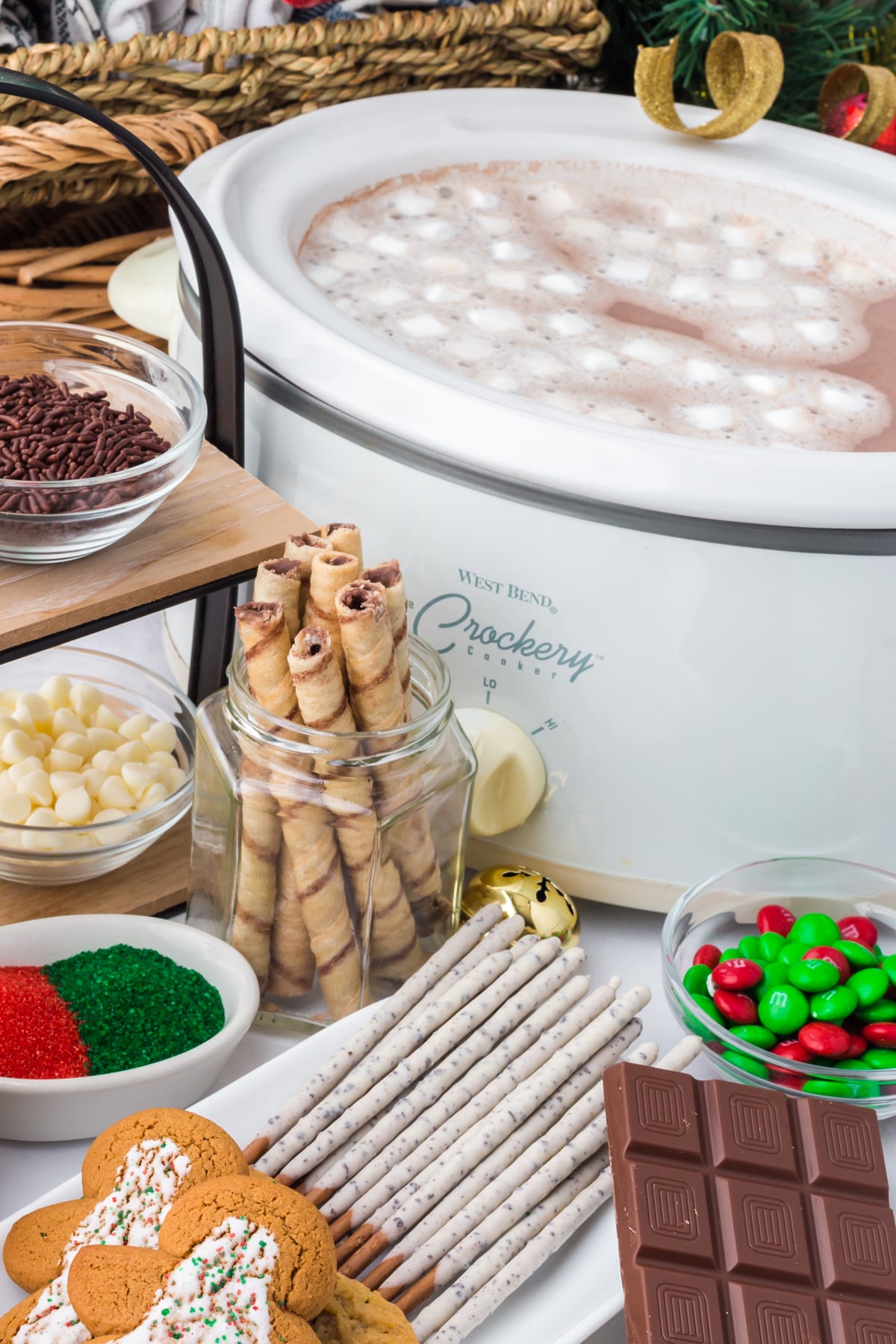 Sauces, stirrers, and treats in bowls on table with slow cooker in background.
