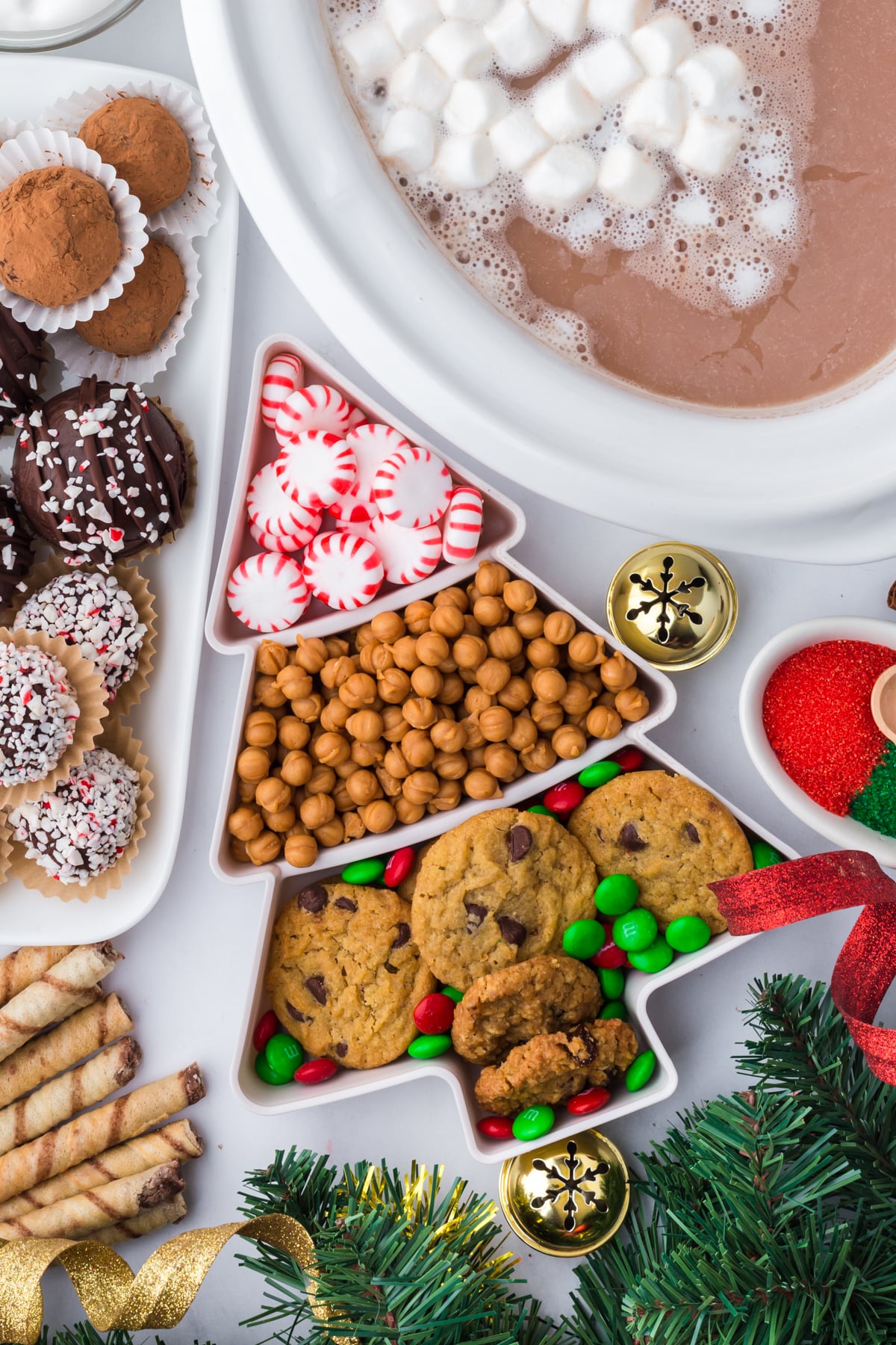Ingredients on display in bowls on a table including a slow cooker full of hot chocolate.