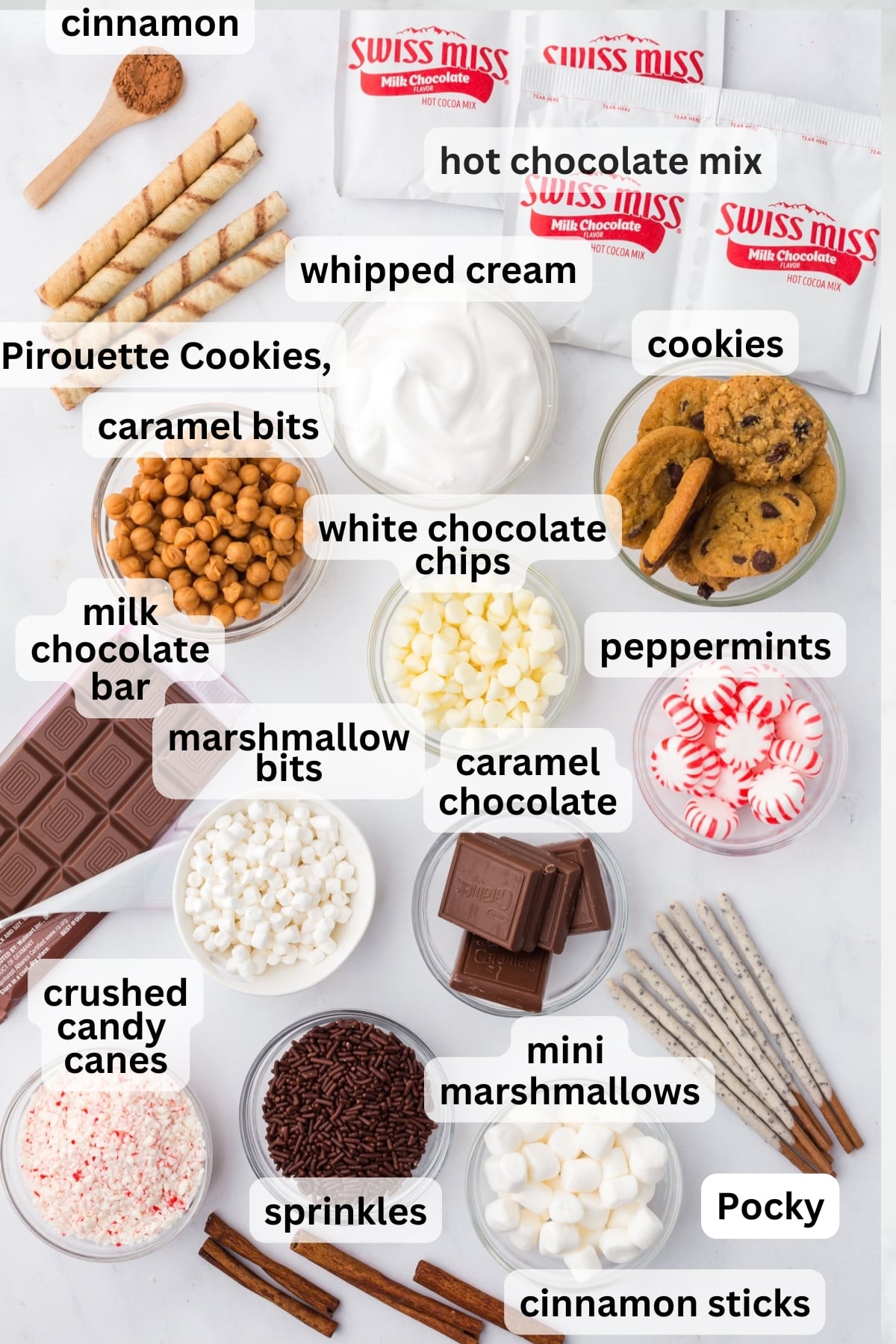 All of the ingredients needed to make a hot chocolate bar in bowls on a table.