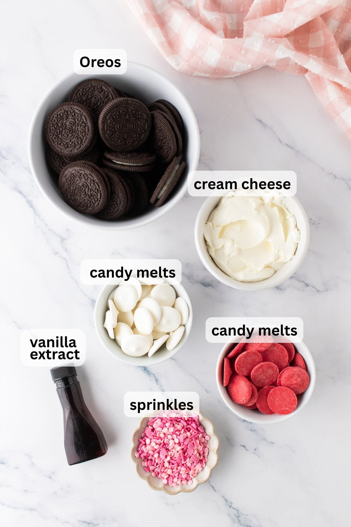 All of the ingredients needed to make Oreo hearts in bowls on a table.