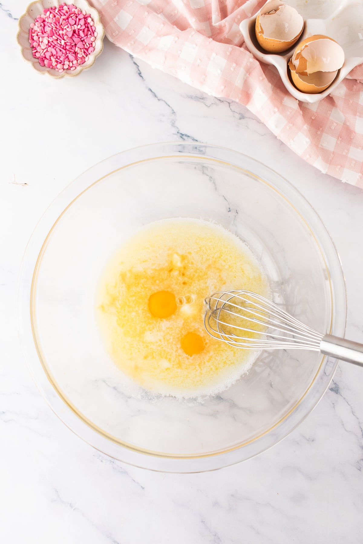 Melted butter, egg, egg yolk, and vanilla whisked in a mixing bowl.
