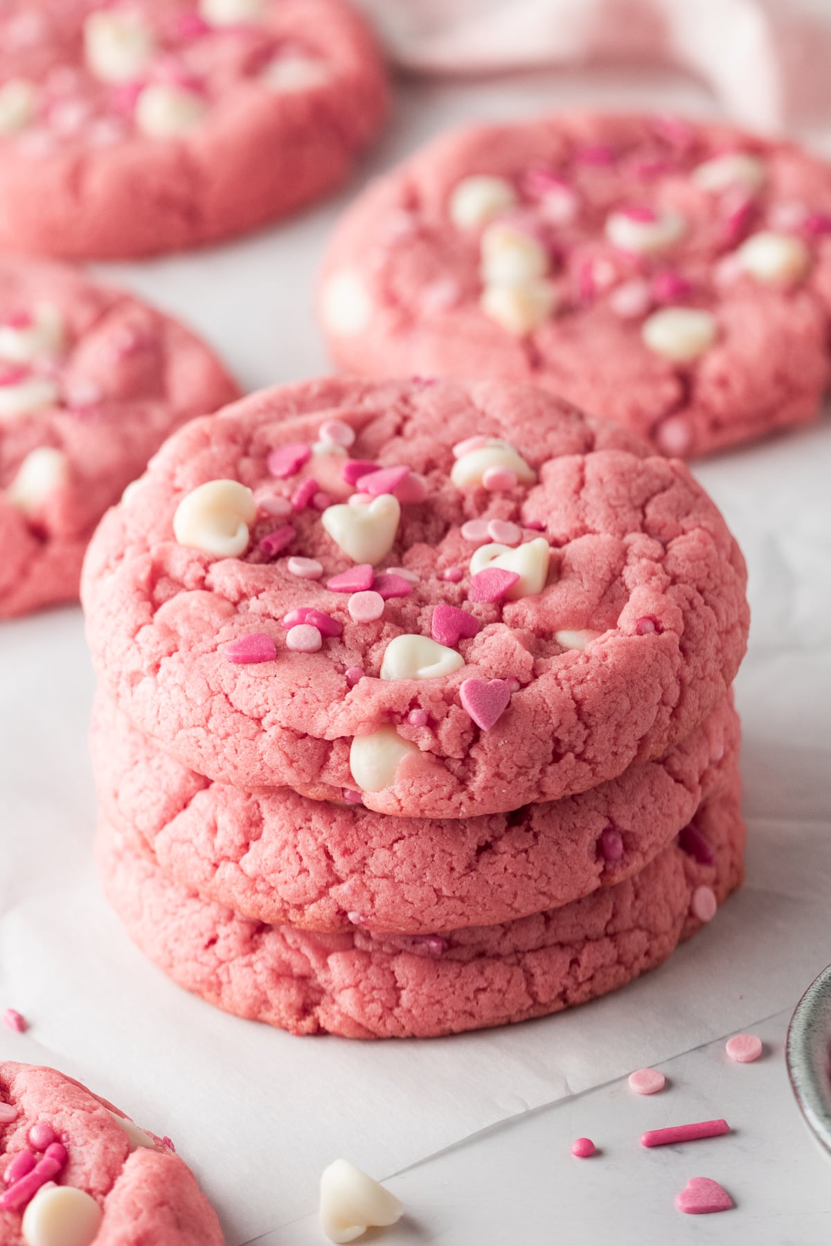 A stack of pink velvet cookies on parchment.