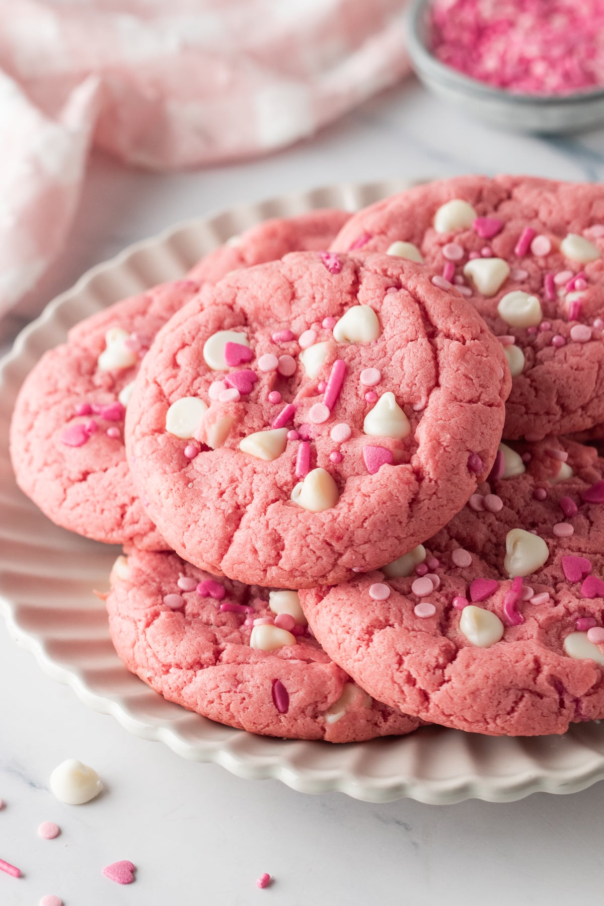 A pile of pink velvet cookies on a serving plate.