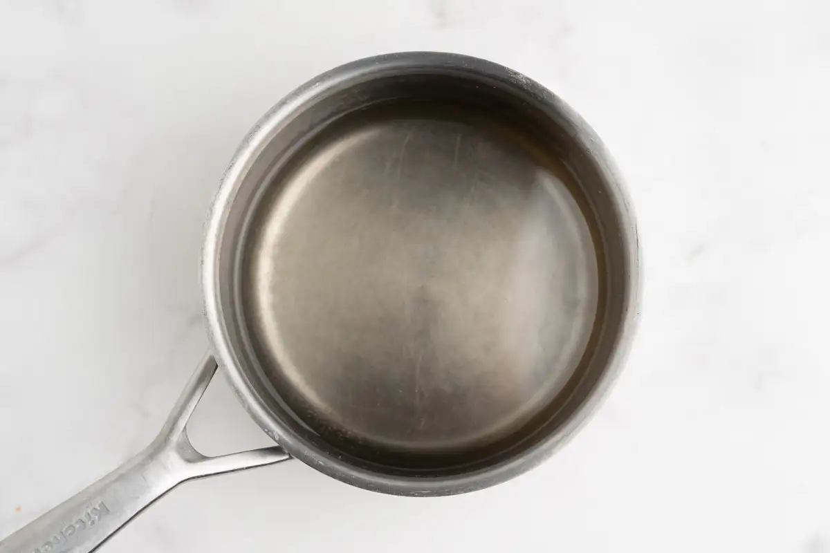 Clear syrup gently simmering in a saucepan.