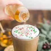 Starbucks sugar cookie syrup being poured into a cold foam topped sugar cookie frappuccino.