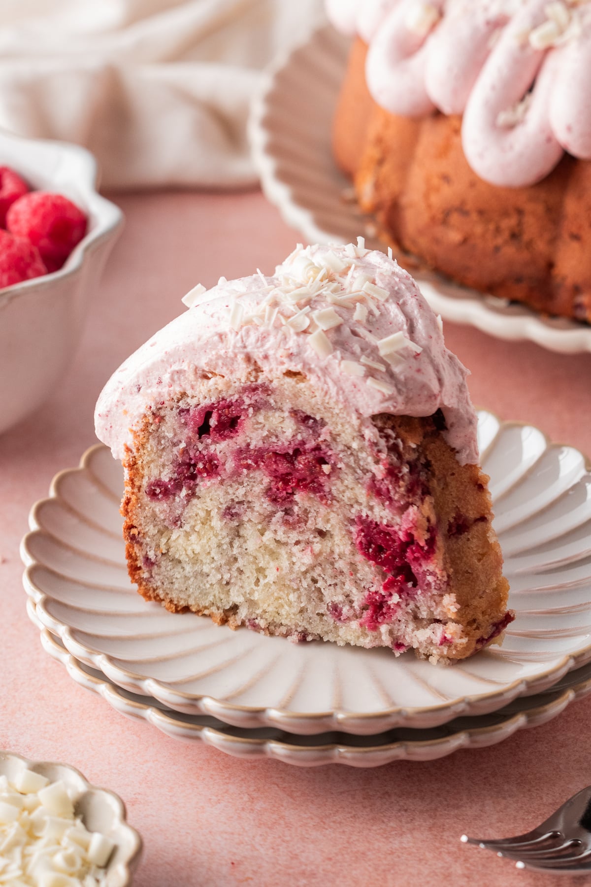 A slice of white chocolate raspberry Bundt cake on a plate.