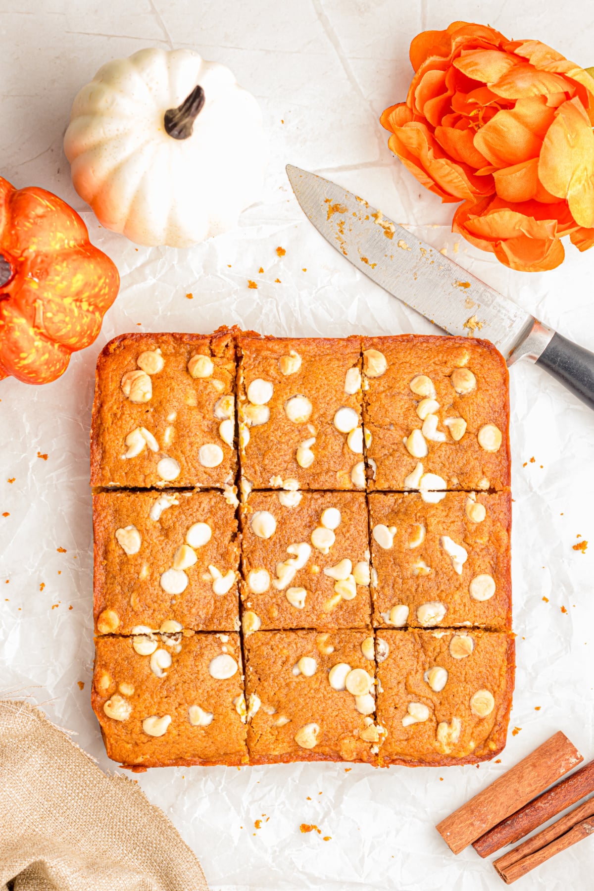 Sliced pumpkin blondies on parchment paper.