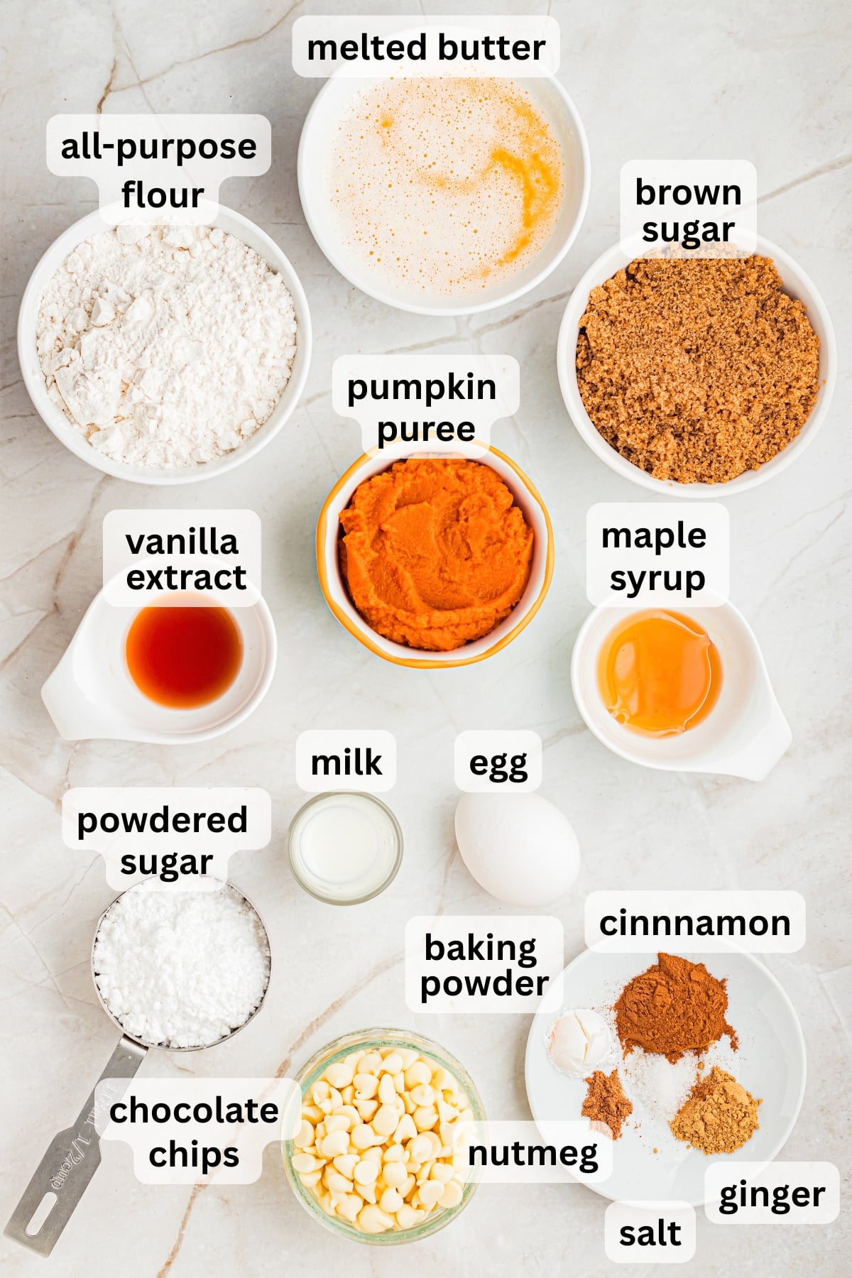 All of the ingredients needed to make pumpkin blondies in bowls on a table.